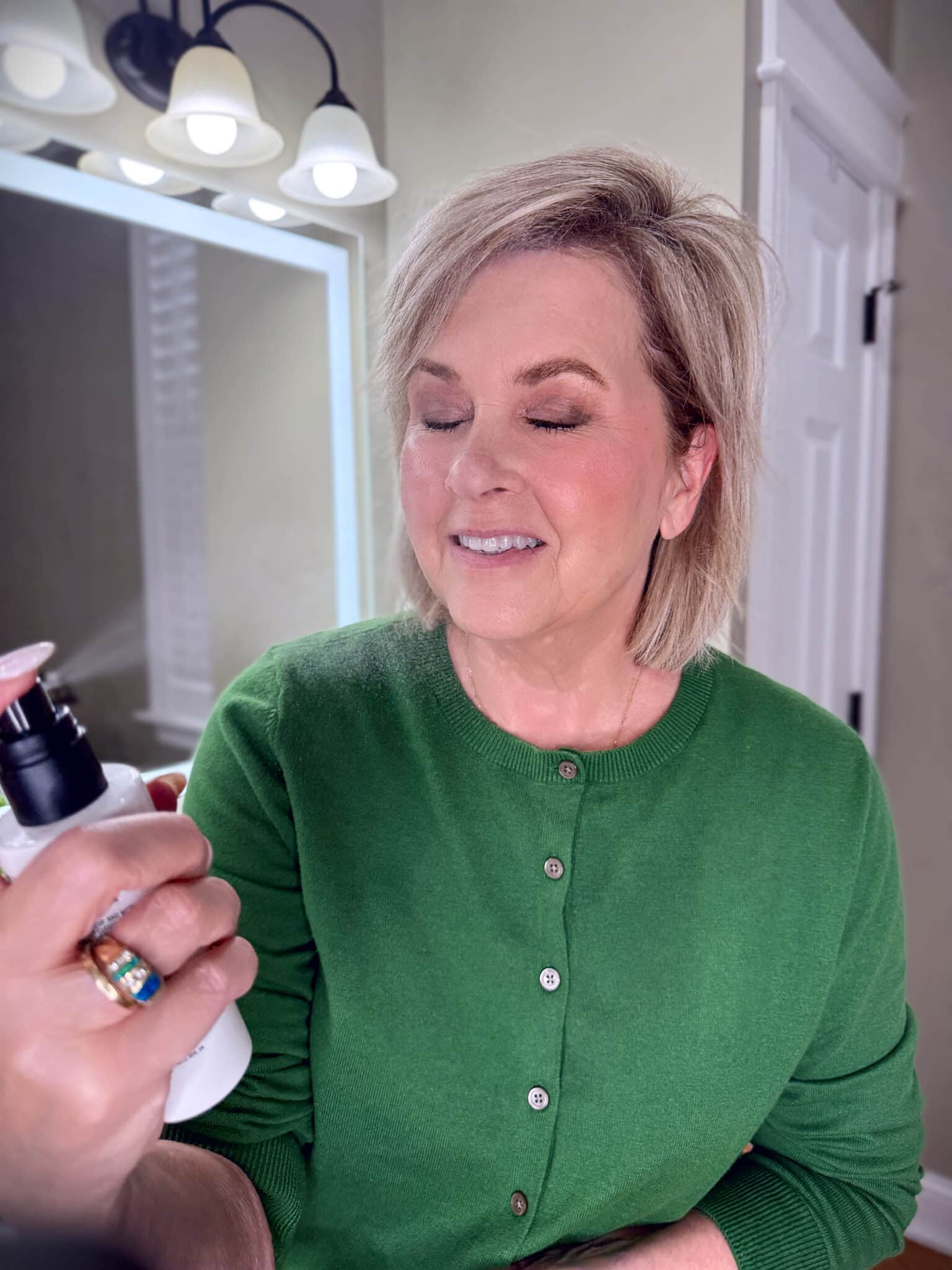 Tania Stephens in a green sweater with using a setting spray makeup from Nordstrom Beauty