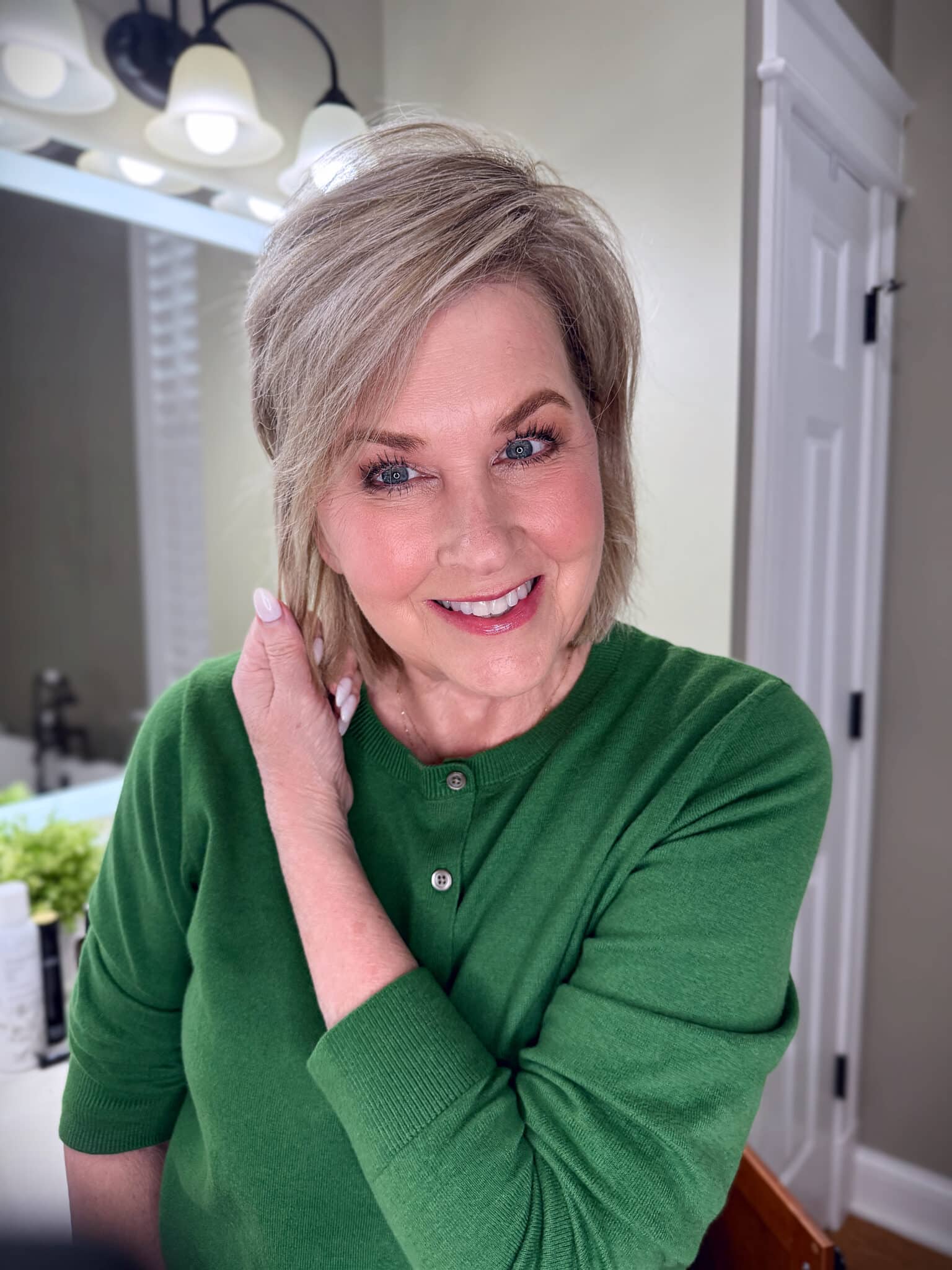 Tania Stephens in a green sweater with finished spring makeup from Nordstrom Beauty