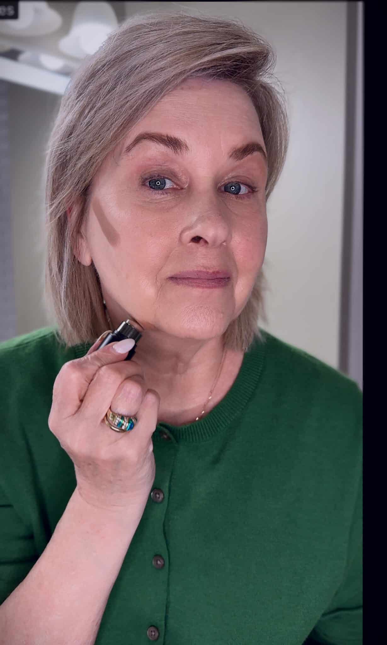 Tania Stephens in a green sweater with applying contour makeup from Nordstrom Beauty