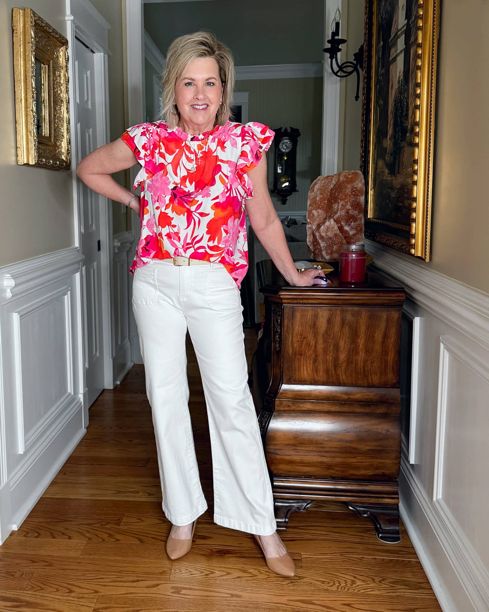 Tania Stephens is wearing a pair of white jeans and a bright pink flutter sleeve top from Amazon