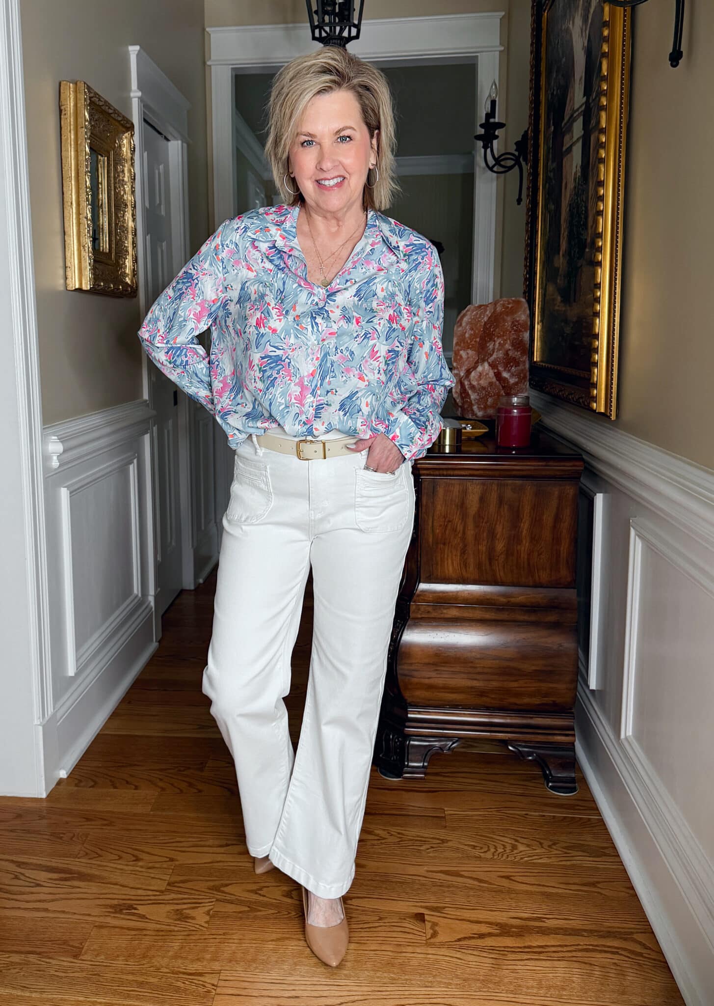 Tania Stephens is wearing a pair of white jeans and a tucked blue print button up shirt from Amazon