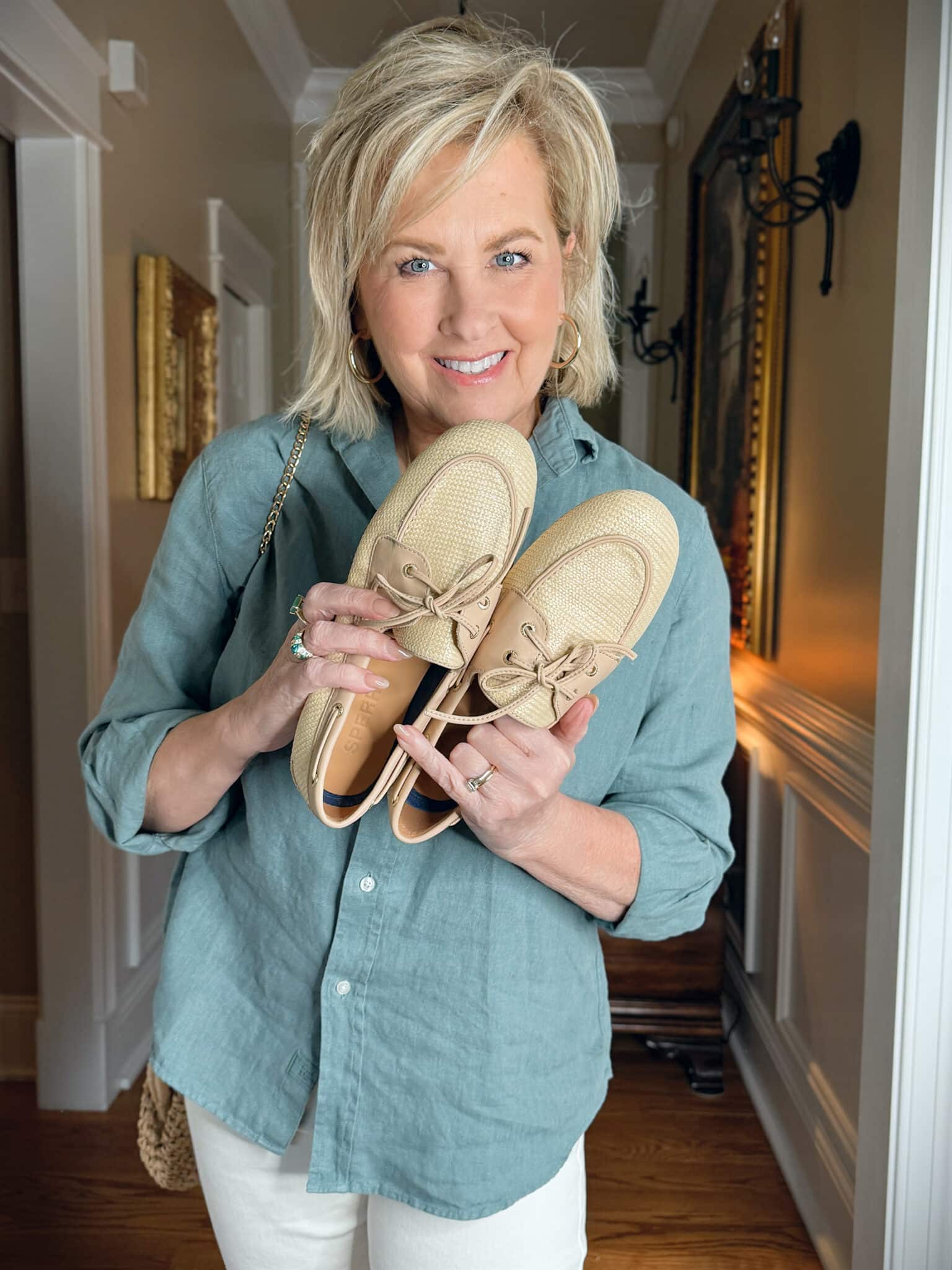 Tania Stephens wearing Frank & Eileen green linen button up shirt and holding a pair of boat shoes