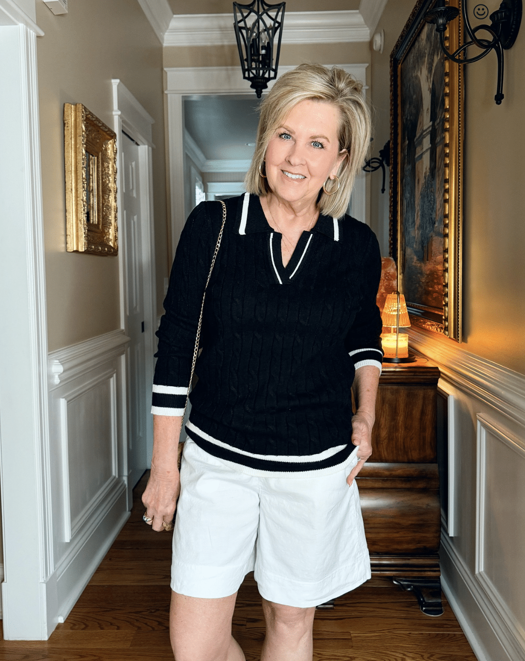Tania Stephens is wearing a black cable knit sweater and Frank & Eileen white shorts