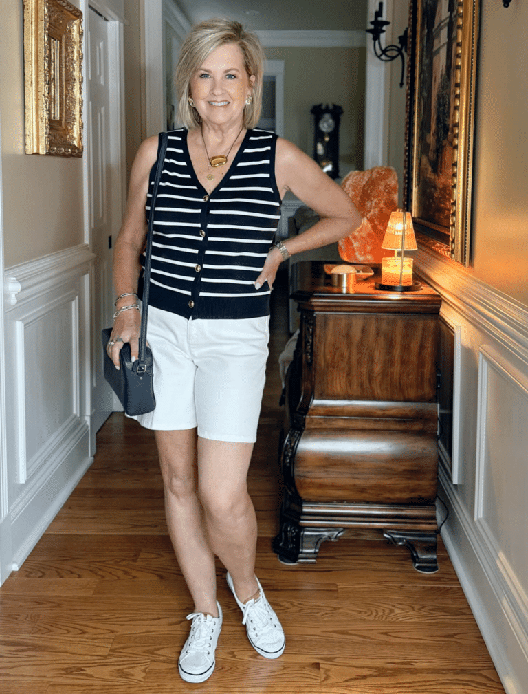 Tania wearing a striped sweater vest with white short and canvas sneakers for a flattering look