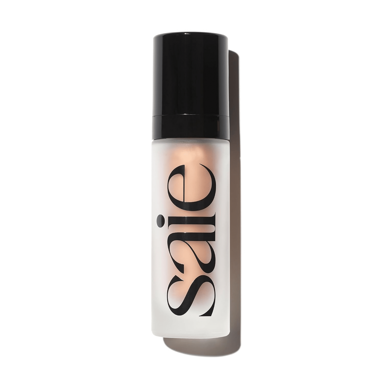 Saie Glowy Super Gel Illuminator bottle photographed in soft daylight. A radiant primer or glow booster worn under or over foundation for a fresh, lit-from-within look.
