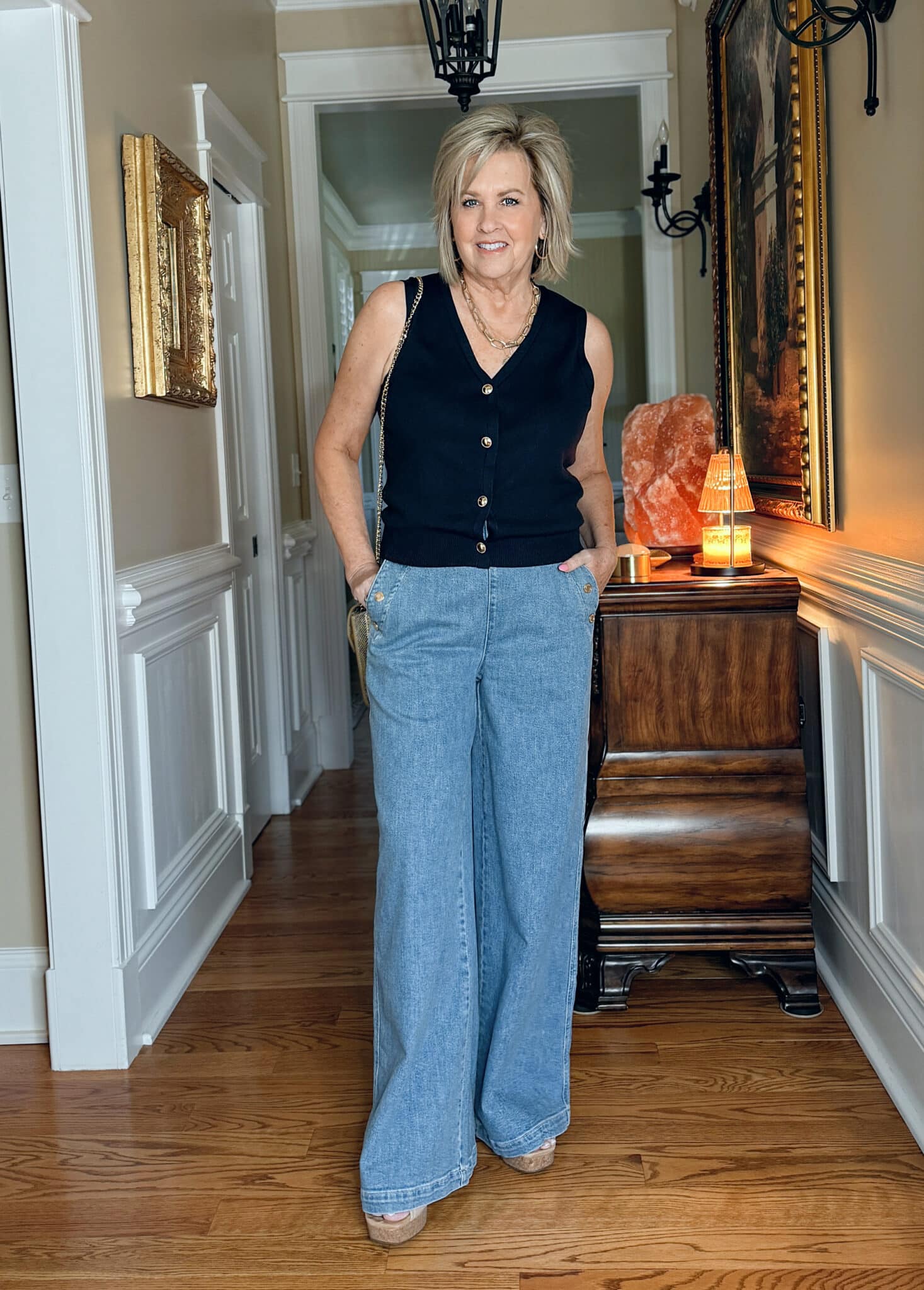 Woman wearing a navy sweater vest for summer with wide leg jeans