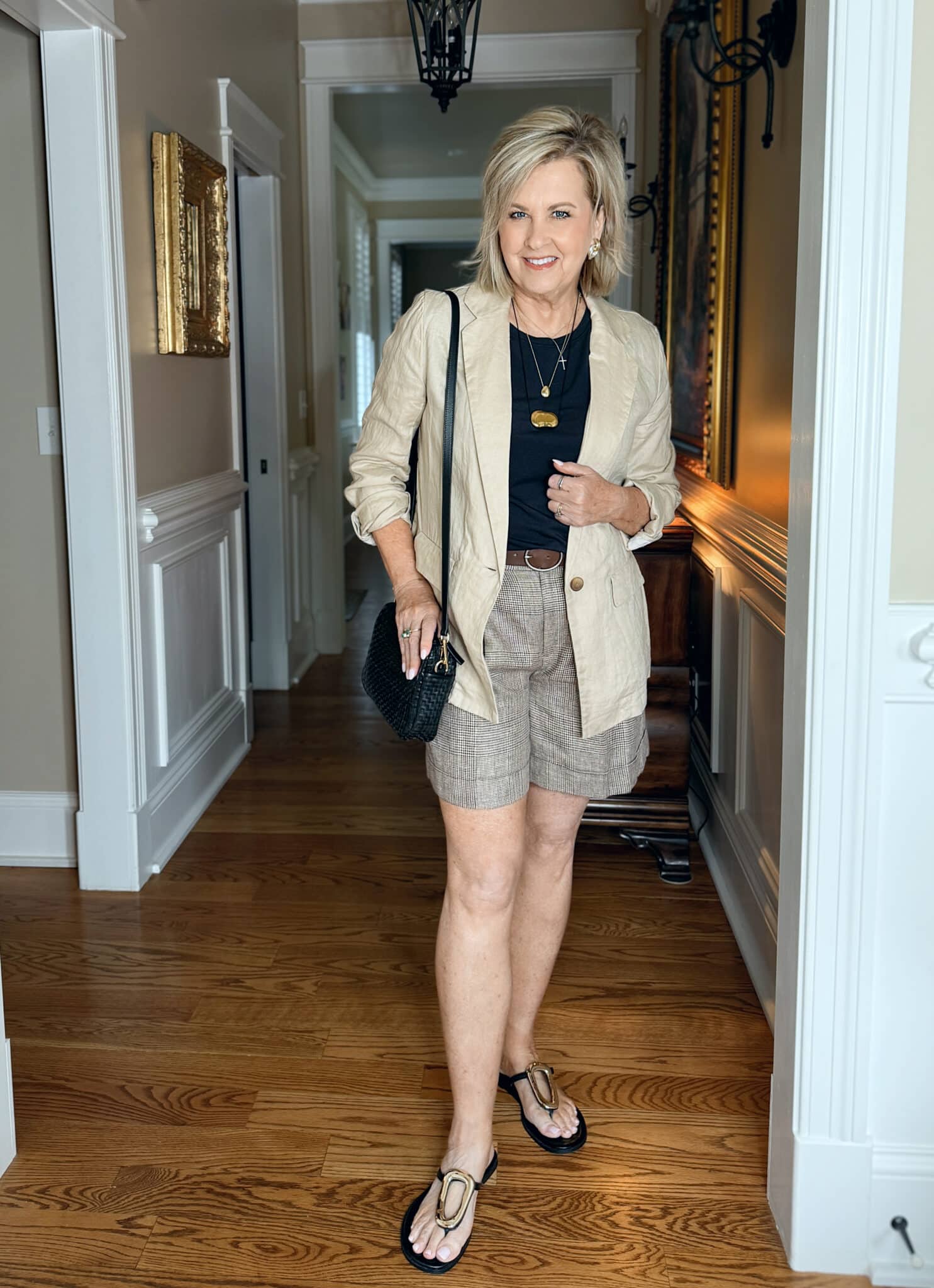 woman wearing a linen blazer with a black top with plaid Bermuda shorts from Macy's
