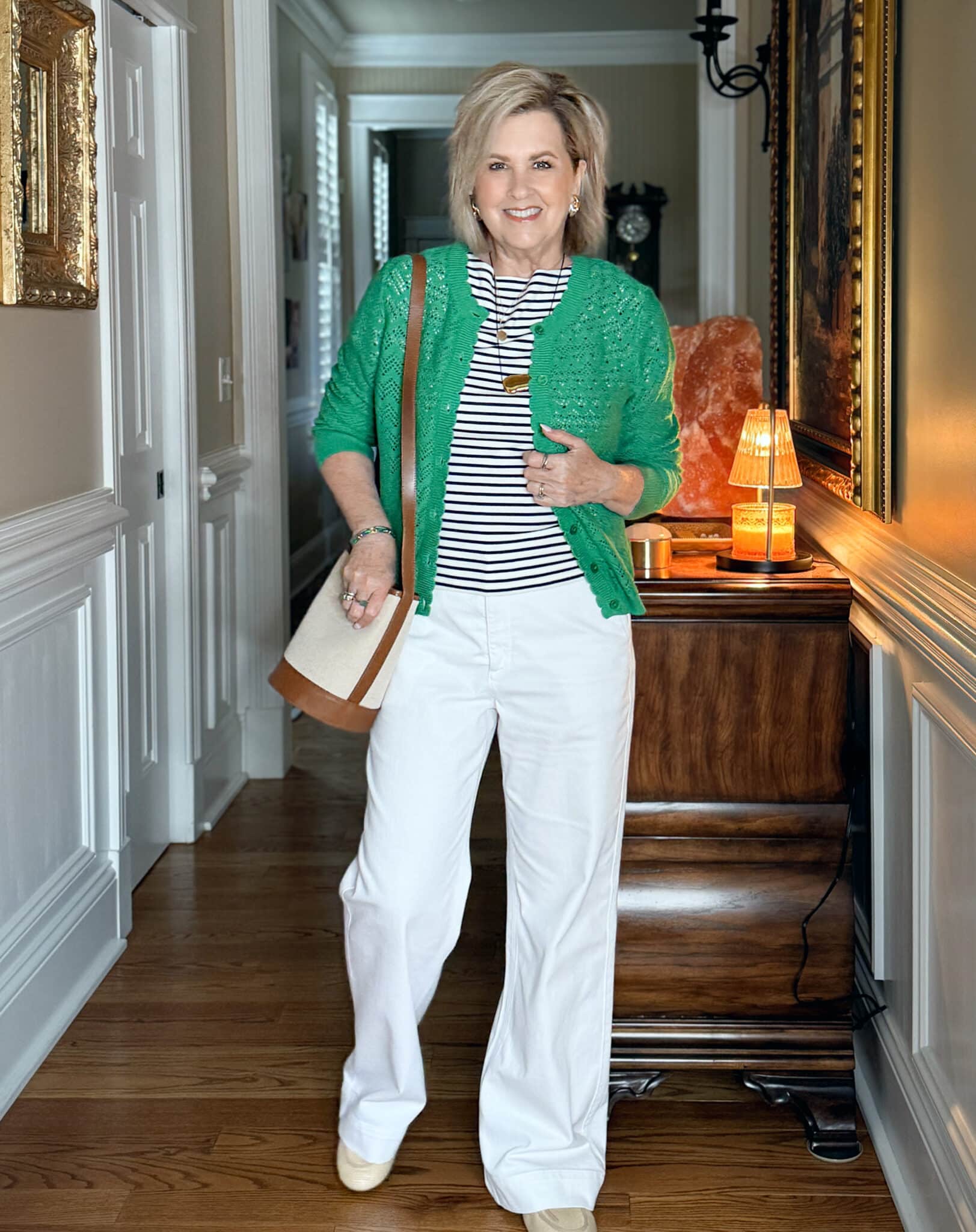 Tania Stephens wearing a sage green scalloped cardigan with white jeans for a classic summer look.