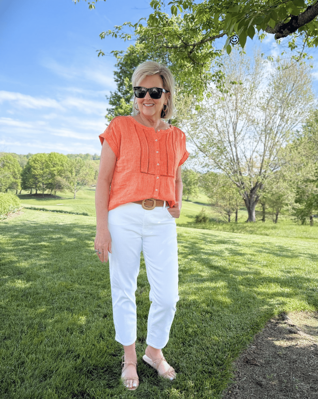 woman wearing white cropped jeans and an orange top