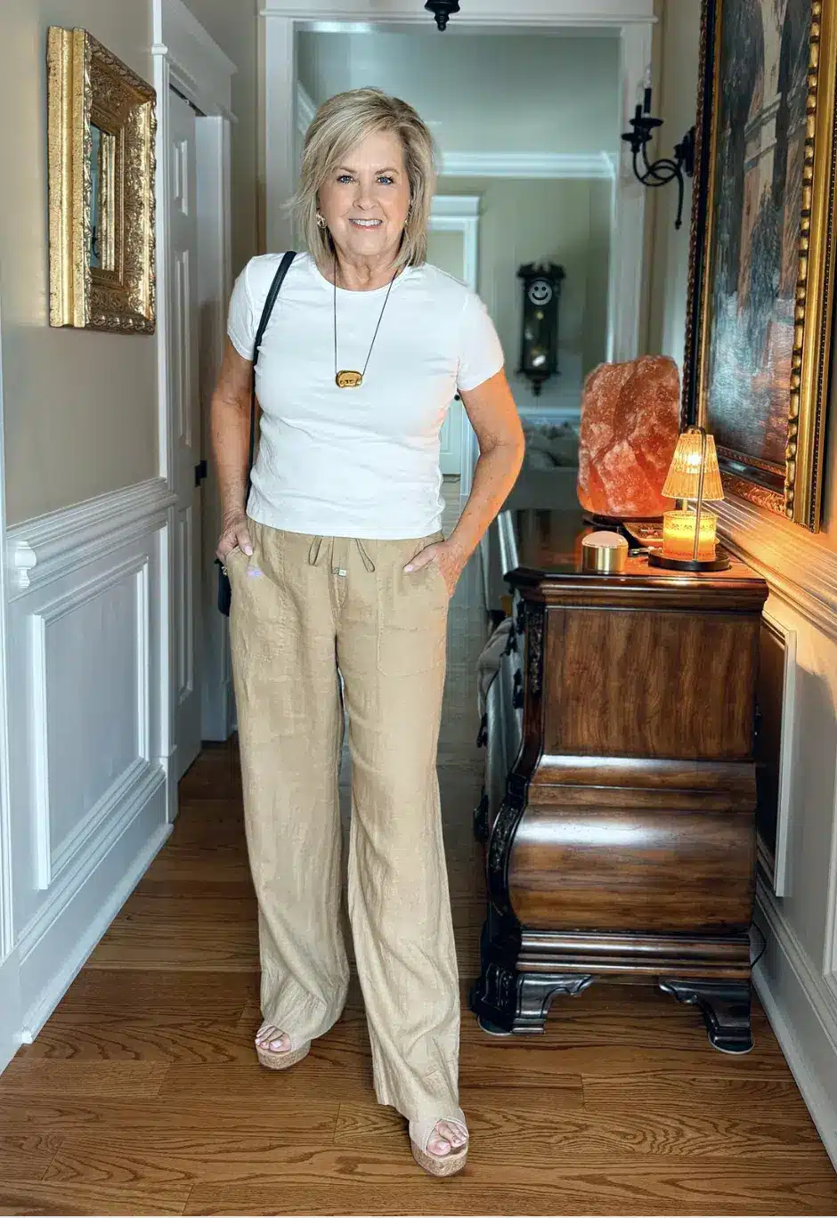 Tania Stephens wearing a white cotton tee with wide-leg linen pants and gold accessories