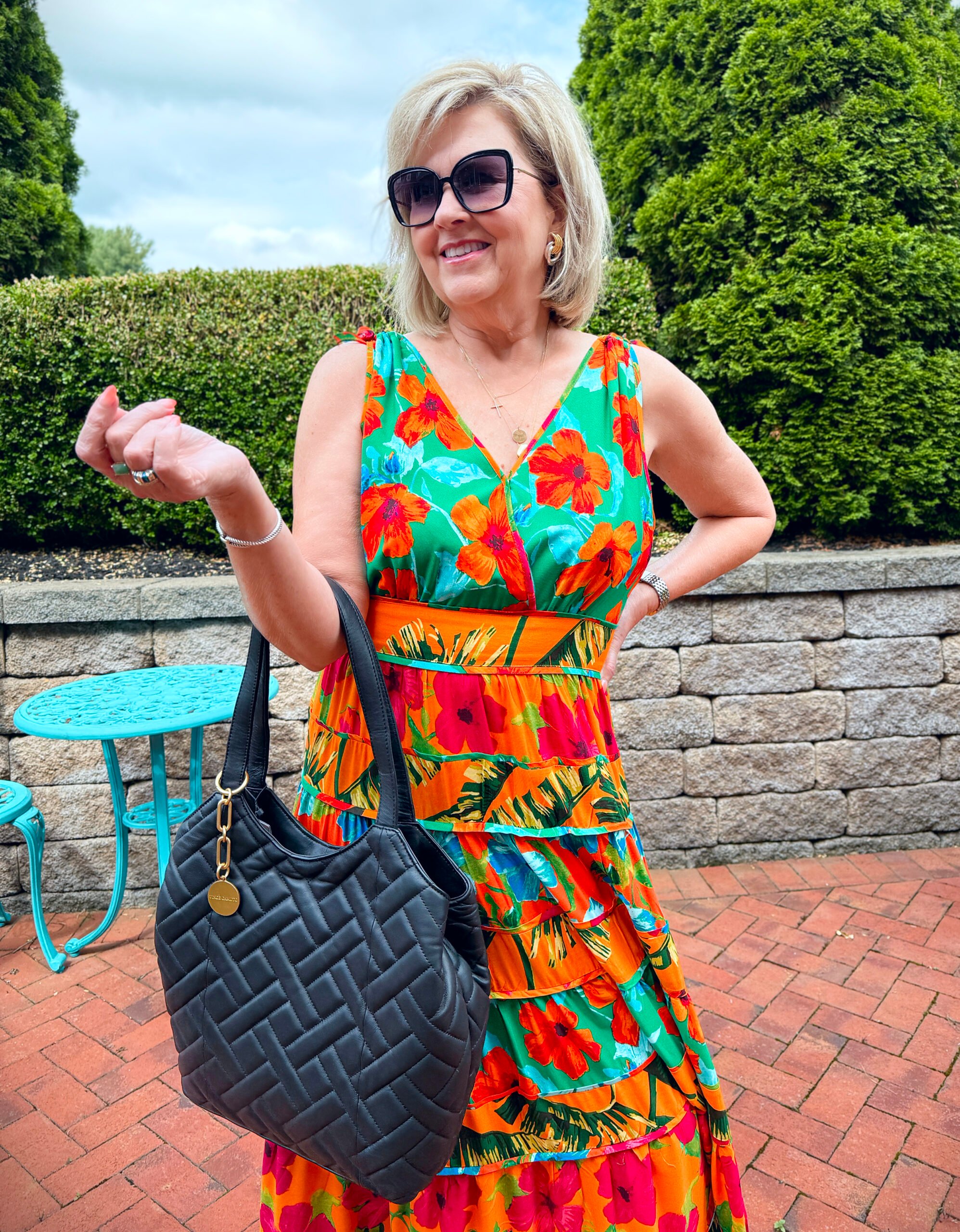 woman wearing colorful maxi dress with a black handbag
