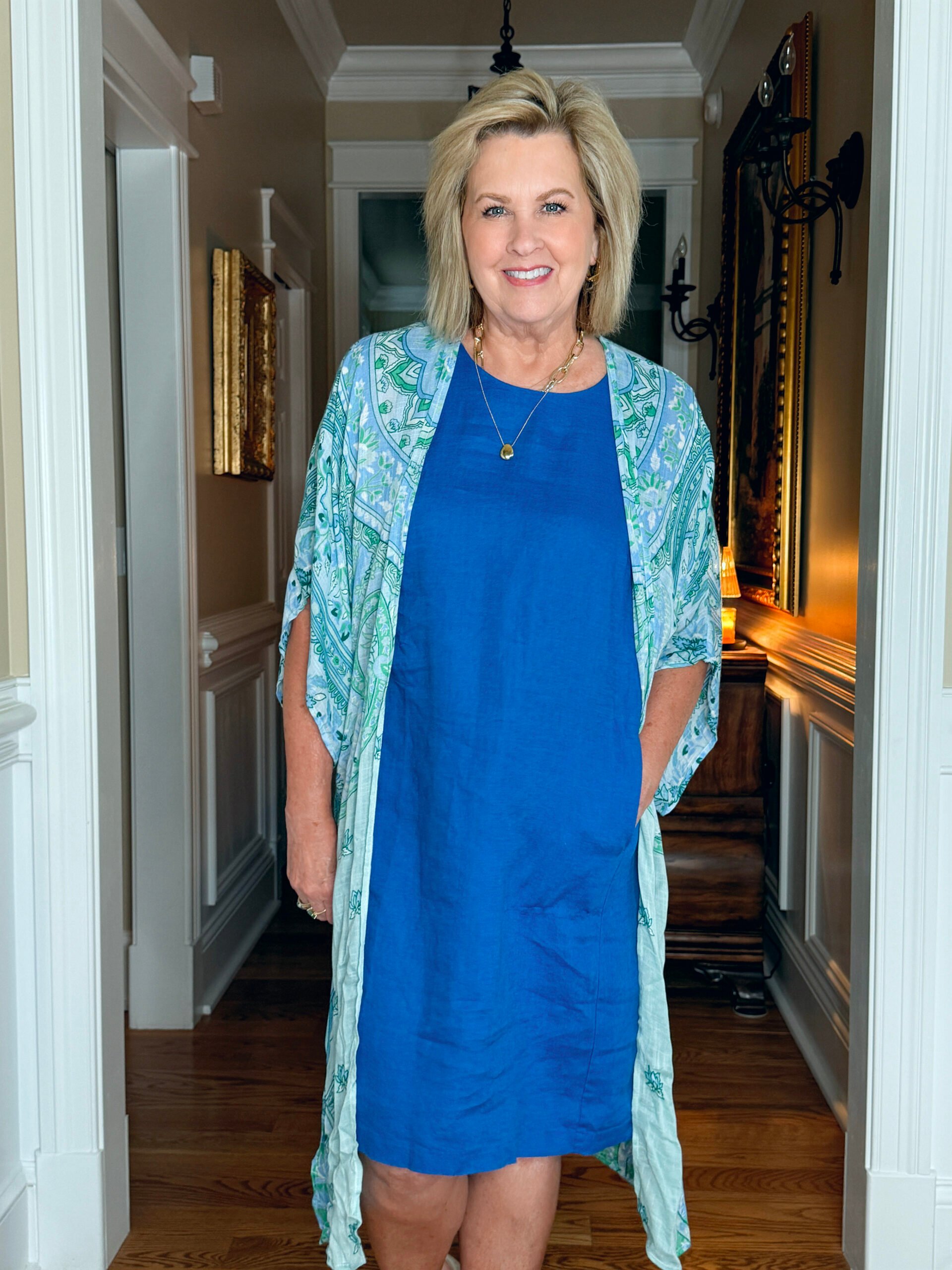Tania wearing a cobalt blue linen dress layered with a paisley duster in mint and blue tones