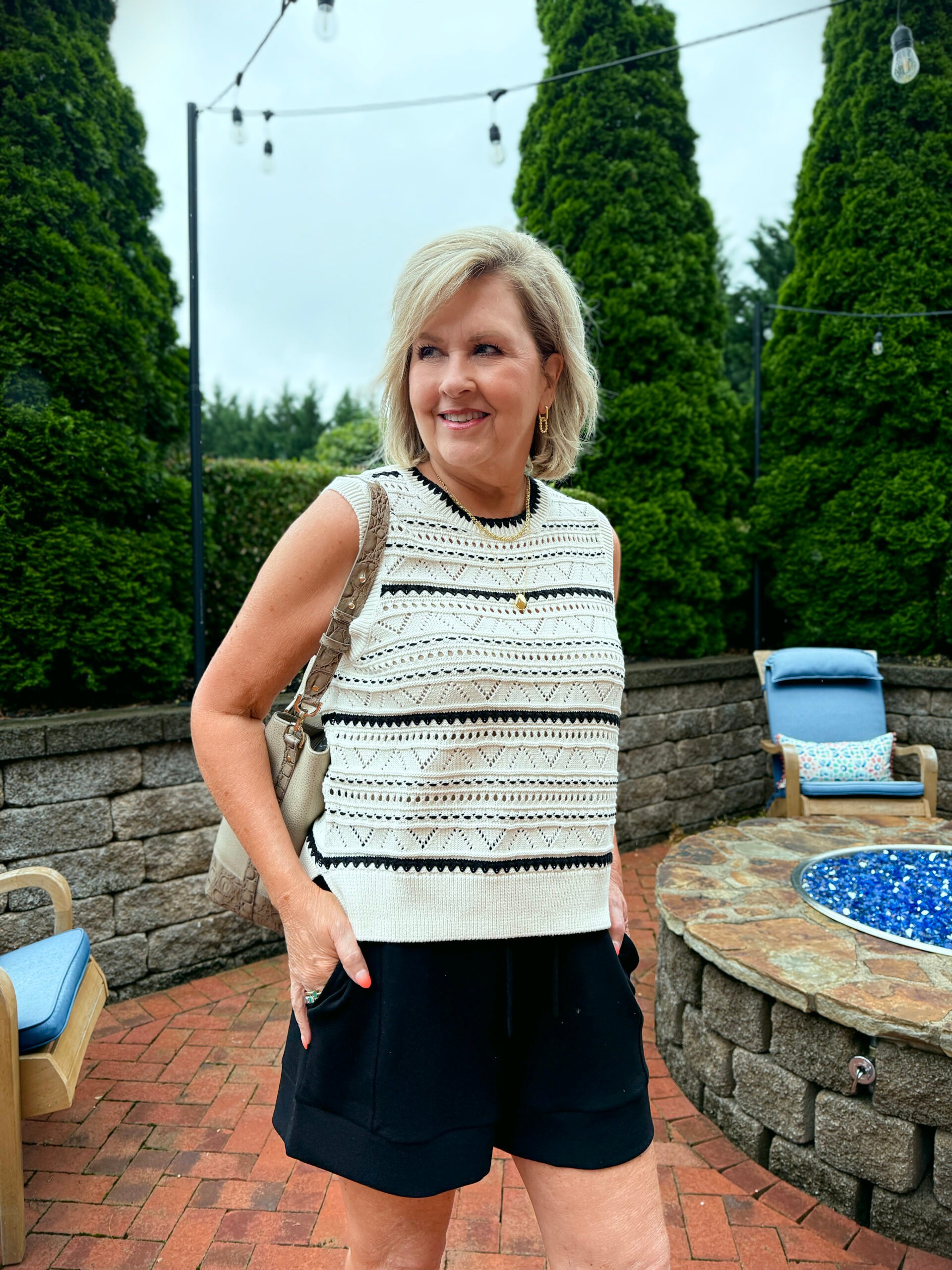Tania on the patio wearing a summer trend - crochet. The top is black and ivory and the shorts are black