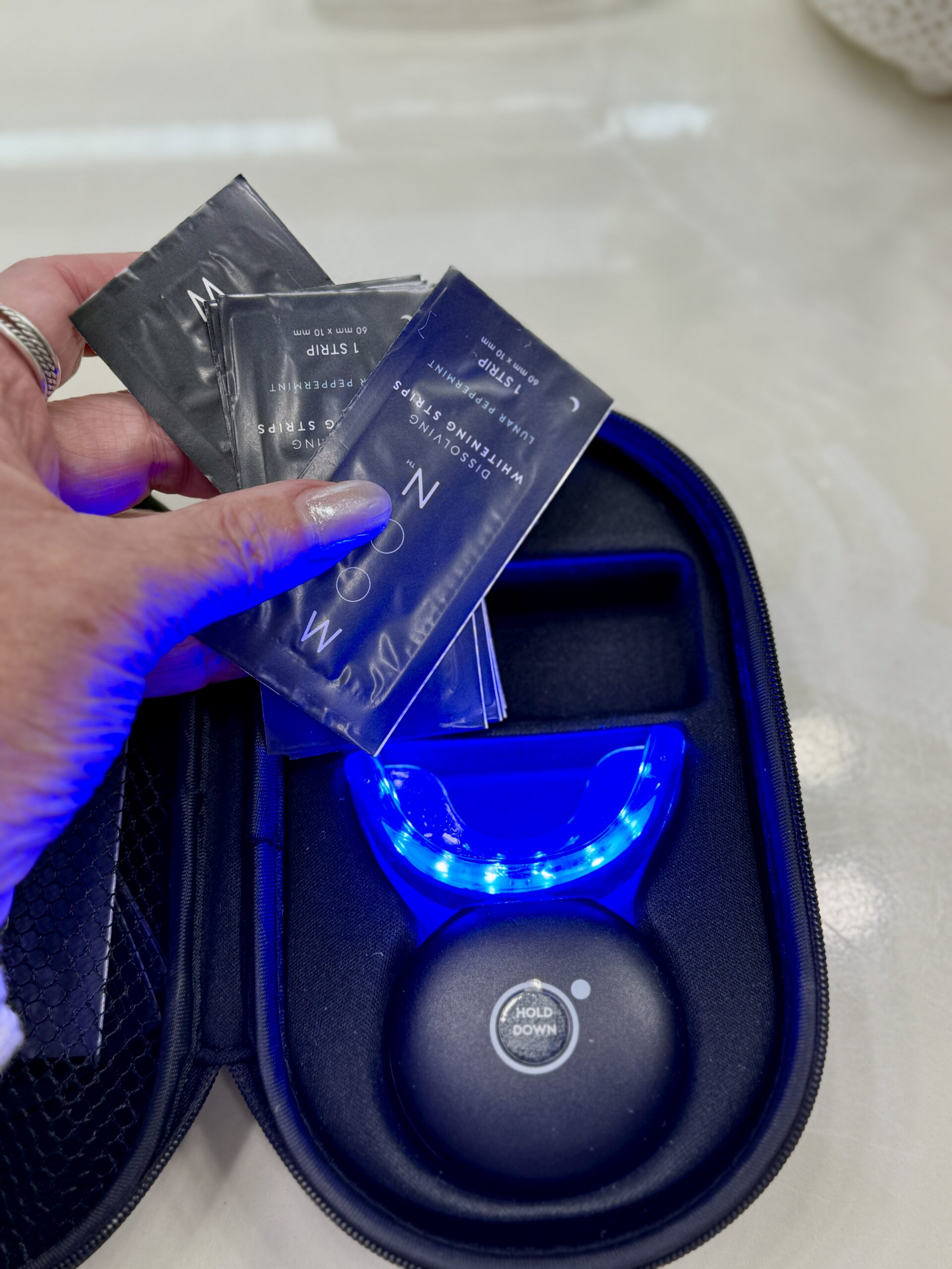 Moon Teeth Whitening System on bathroom counter, compact device with dissolving strips