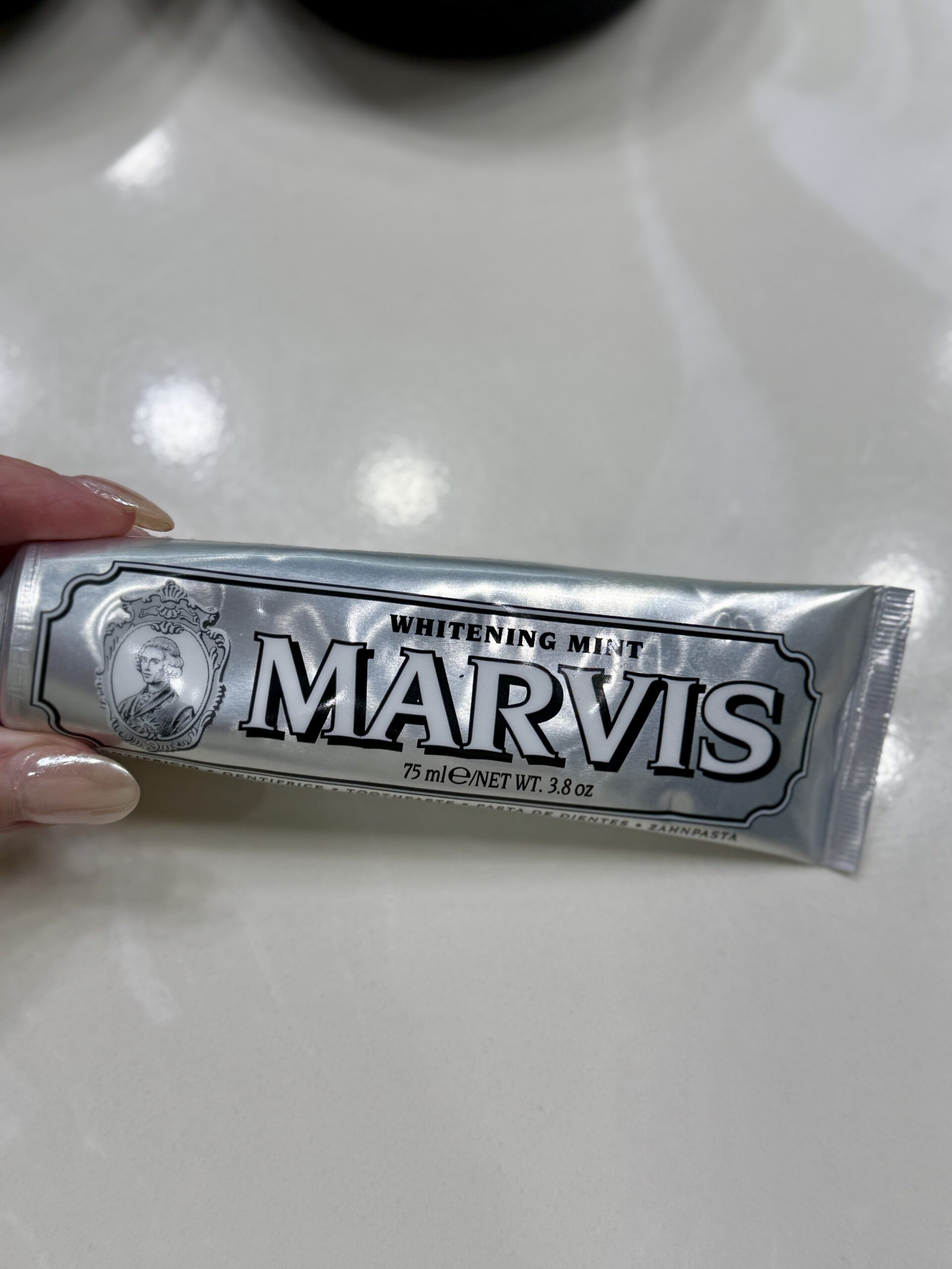 Marvis Whitening Mint Toothpaste tube on marble tray, elegant packaging for mature skincare