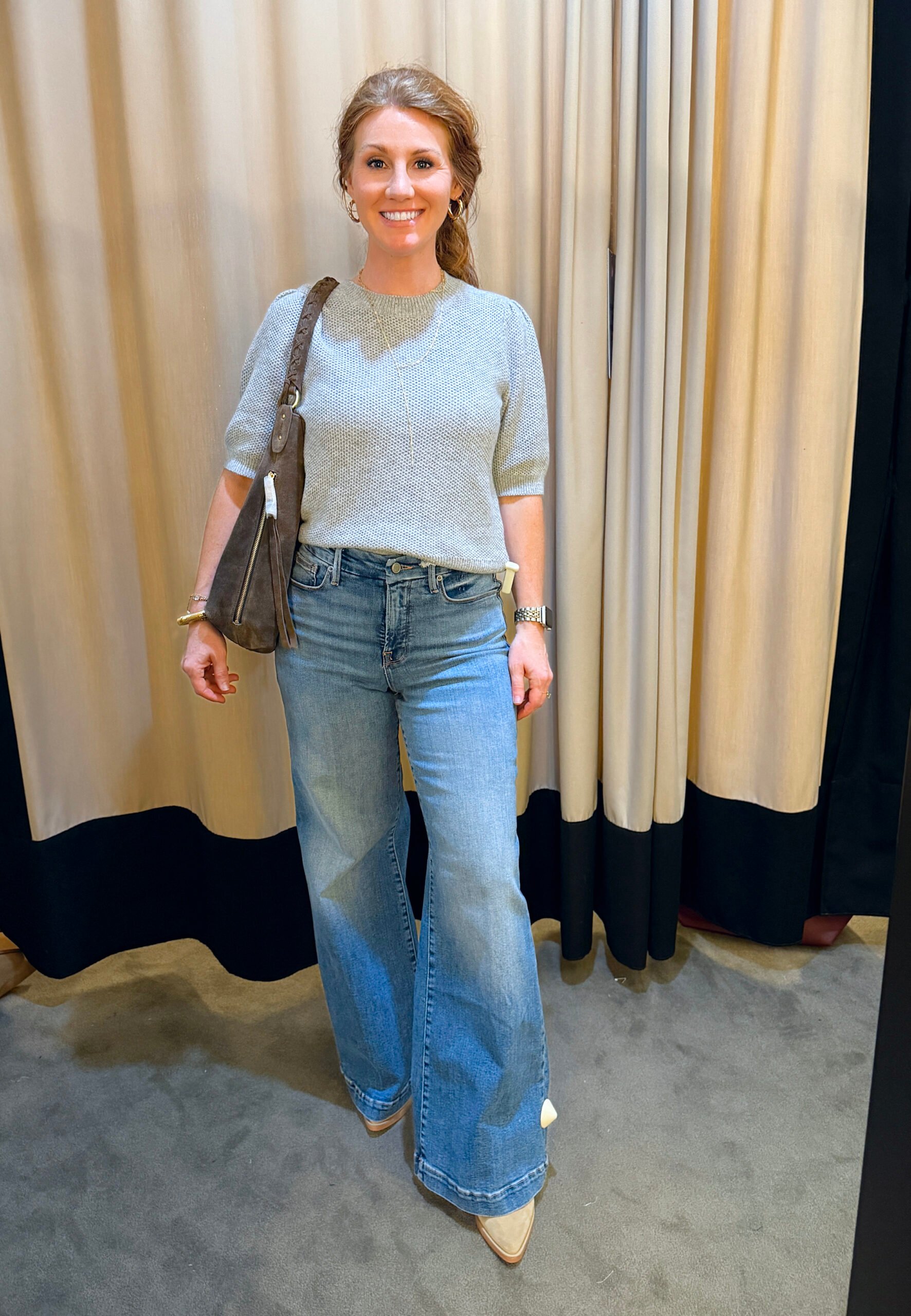 Stephanie wearing a gray sweater and light wash jeans