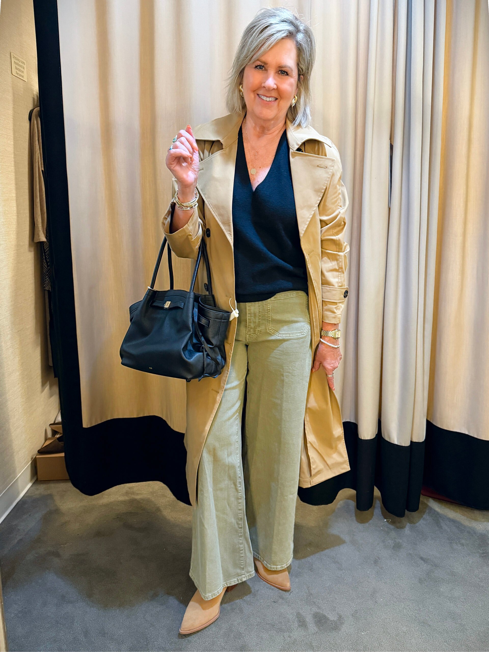 Tania wearing a trench coat with a black cashmere shell and olive pants