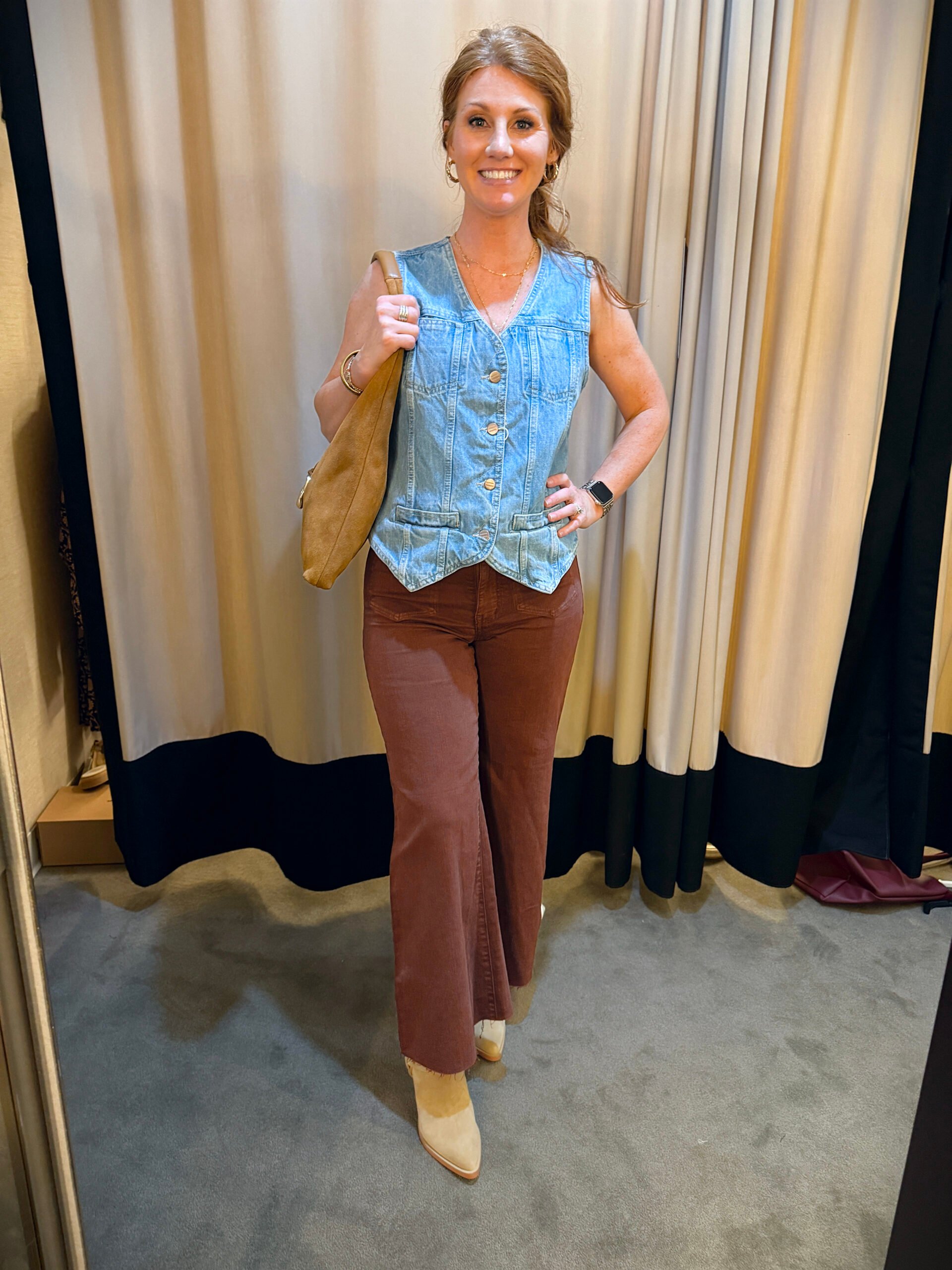 Stephanie wearing a denim vest with brown jeans - a great fall transition outfit to wear now