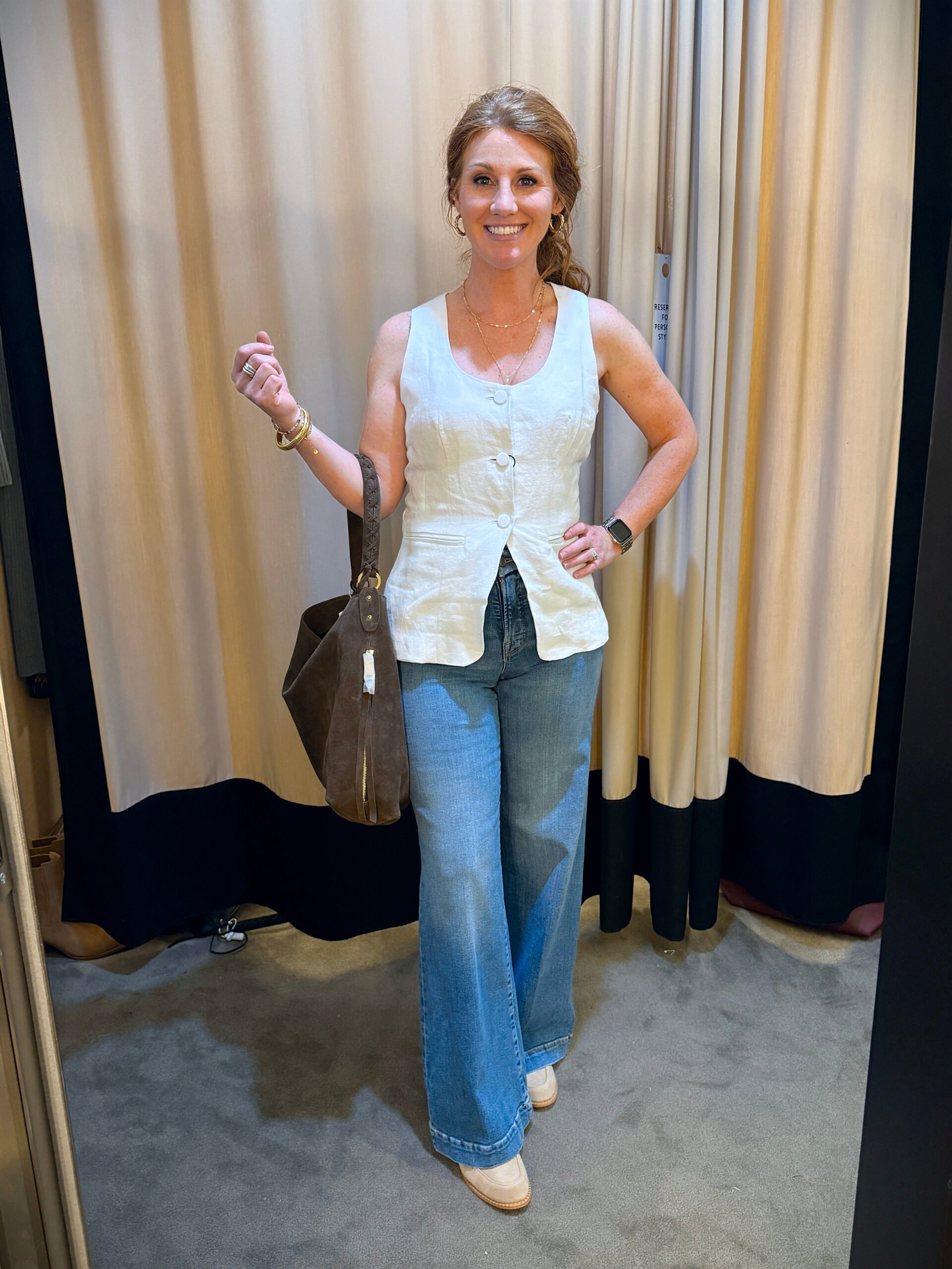 Stephanie wearing a white sleeveless vest with jeans - a great fall transition outfit to wear now