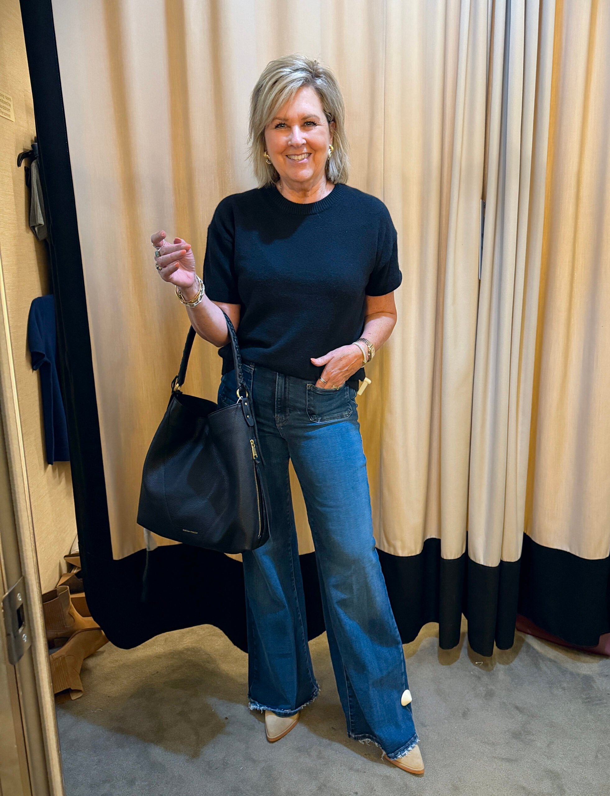 Tania waring a black short sleeve sweater with jeans - a great fall transition outfit to wear now