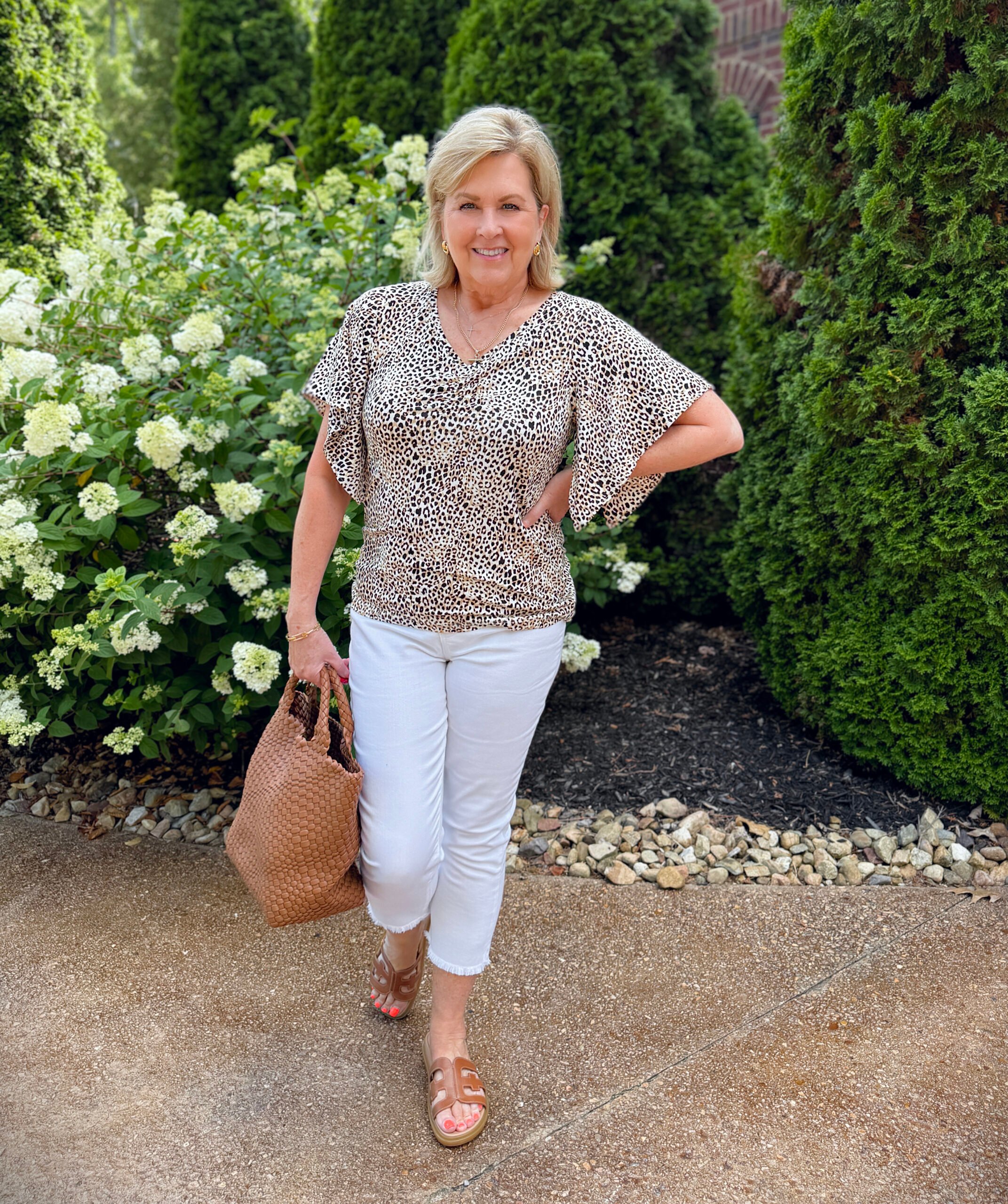 Tania wearing a animal print top from Chico's with white crop jeans