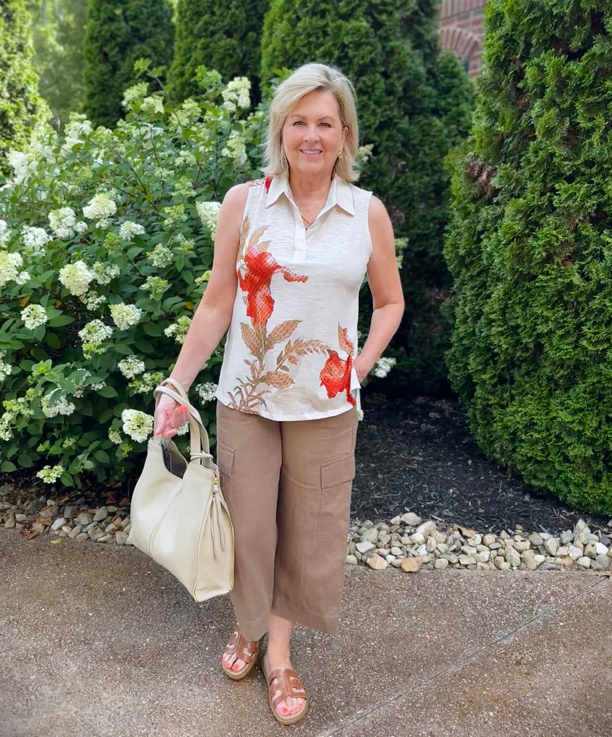 Tania wearing a sleeveless floral  top from Chico's with brown cropped cargo pants