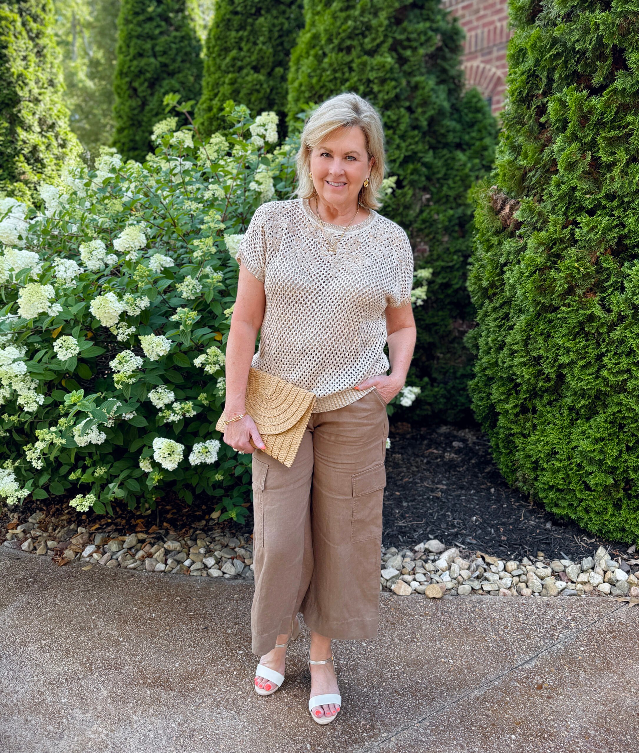 Tania wearing a open knit top from Chico's with brown cropped utility pants