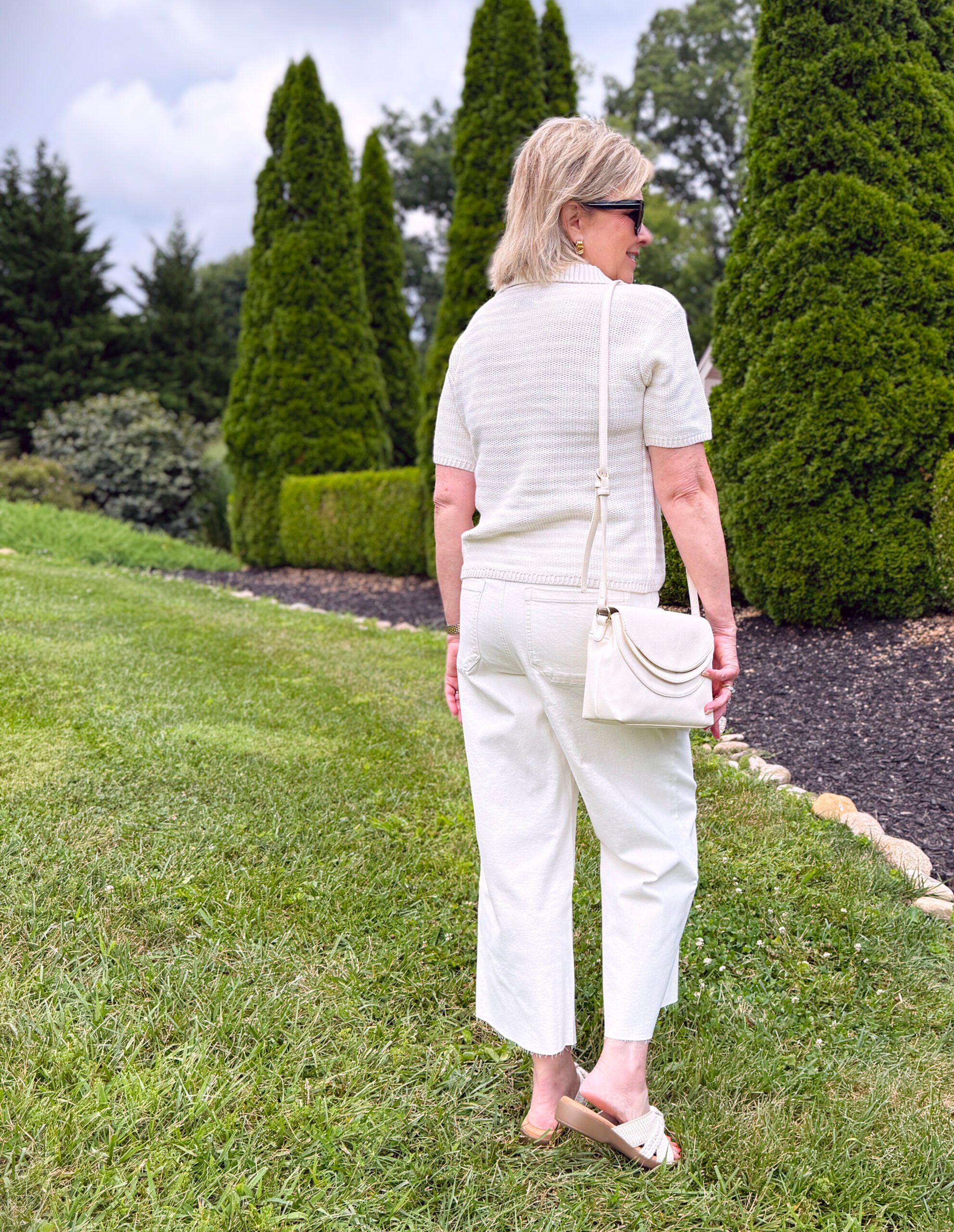 Tania Stephens showing the back of a neutral striped polo sweater and cream wide leg pants from Kohls