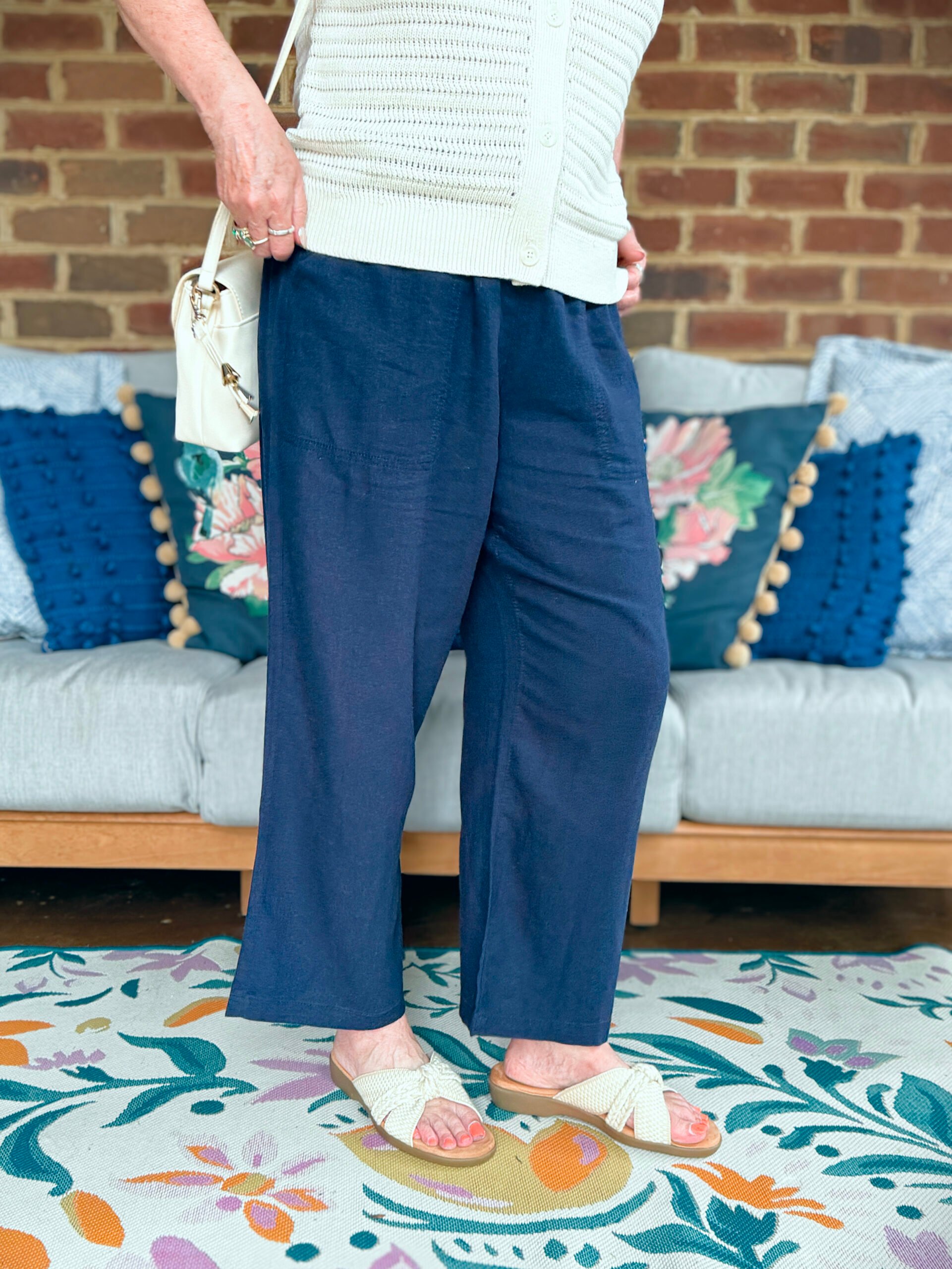 Tania Stephens wearing navy wide leg pants with slip on sandals from Kohls