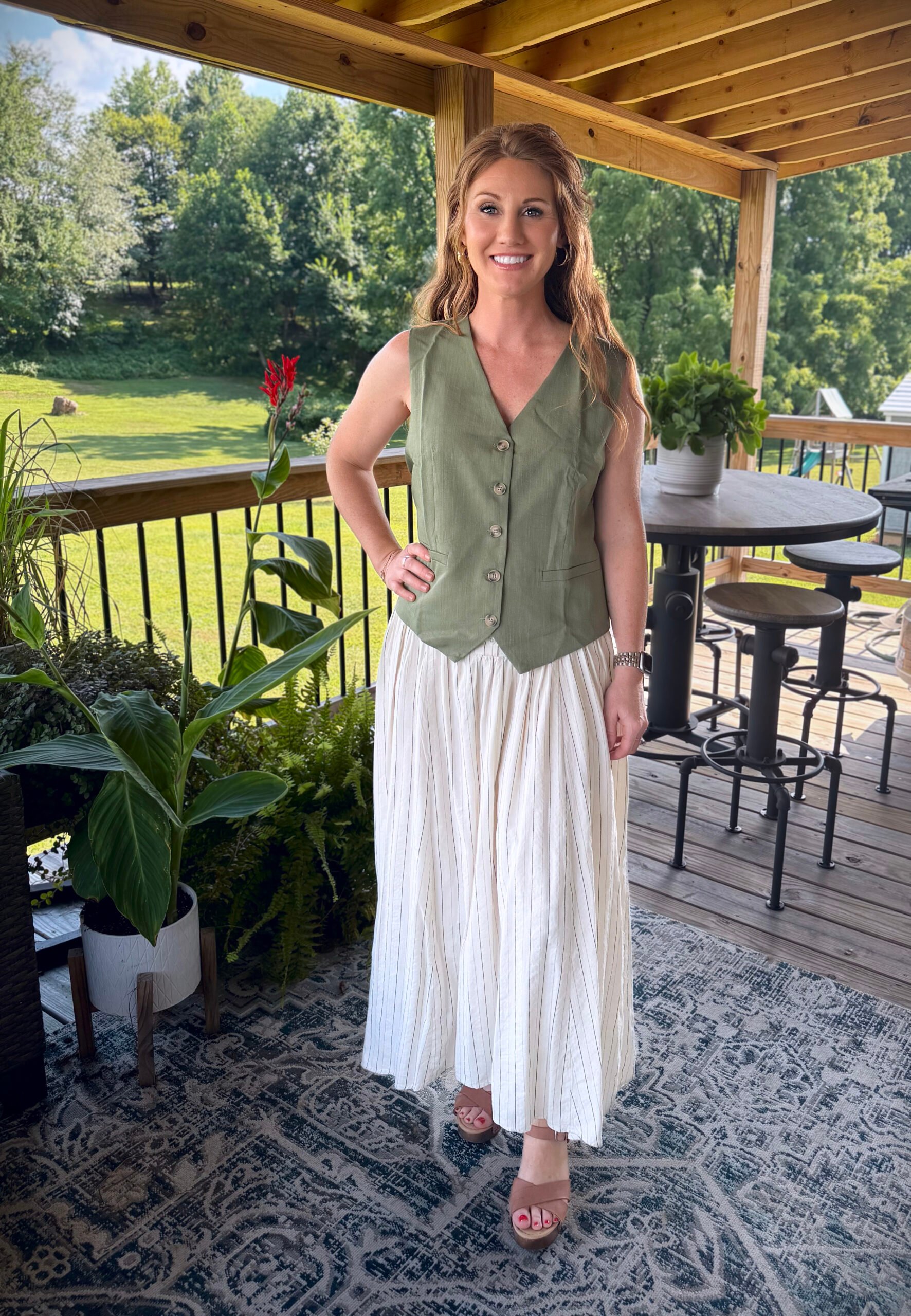 Stephanie, a petite 5'3" tall, wearing a olive green vest from Amazon with a white skirt