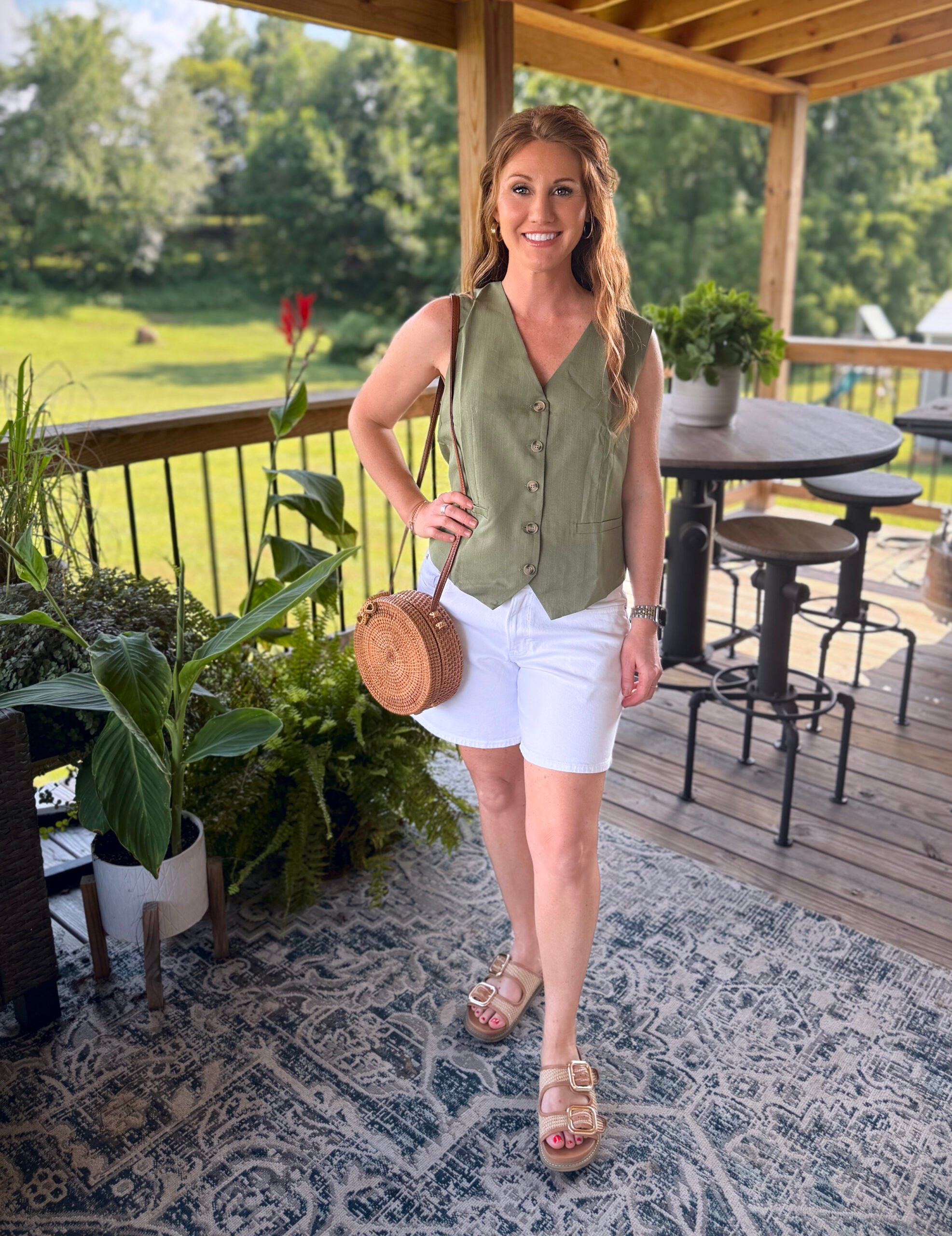 Stephanie, a petite 5'3" tall, wearing a olive green vest from Amazon with white shorts
