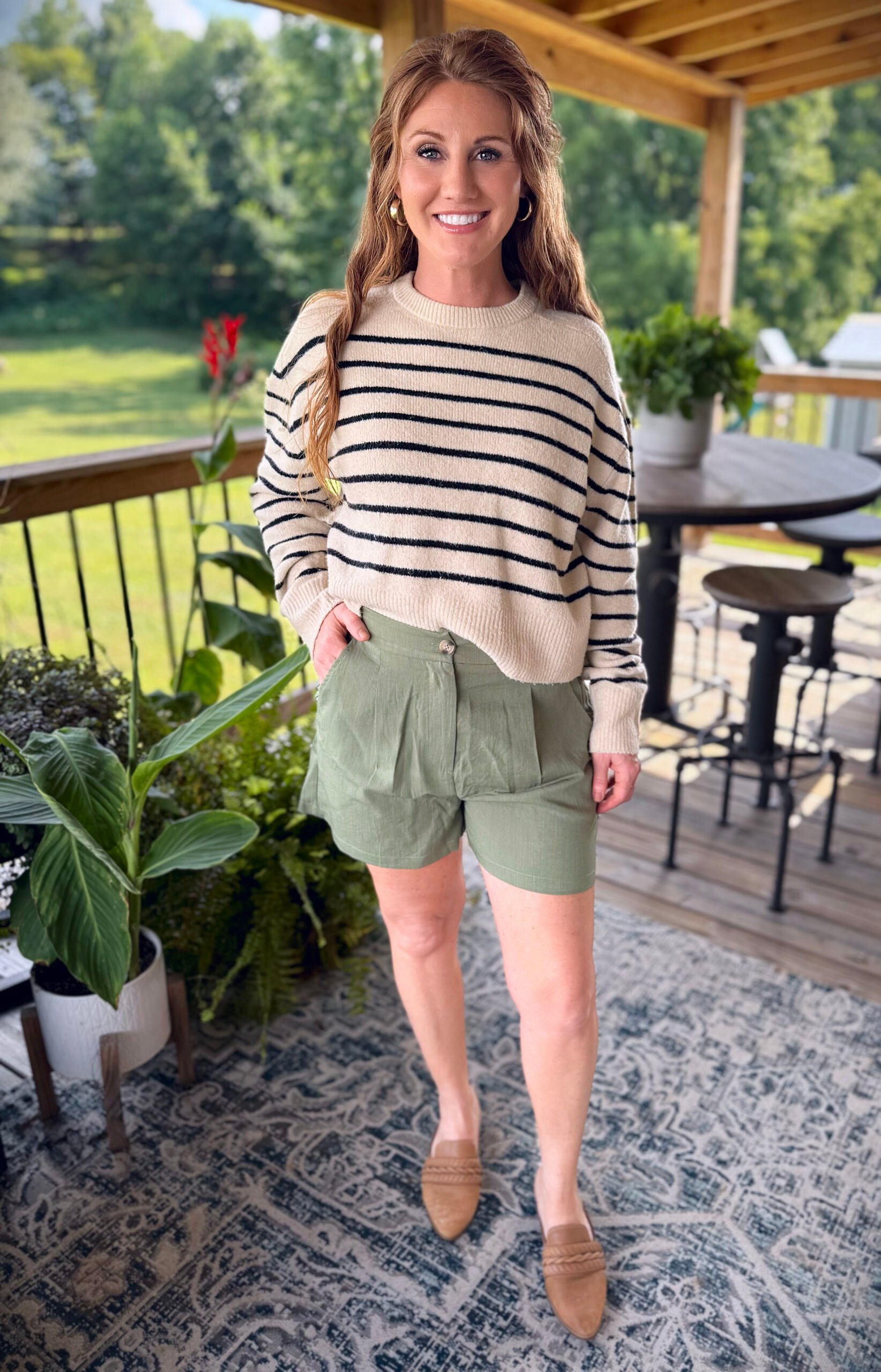 Stephanie, a petite 5'3" tall, wearing olive green shorts from Amazon with a striped sweater