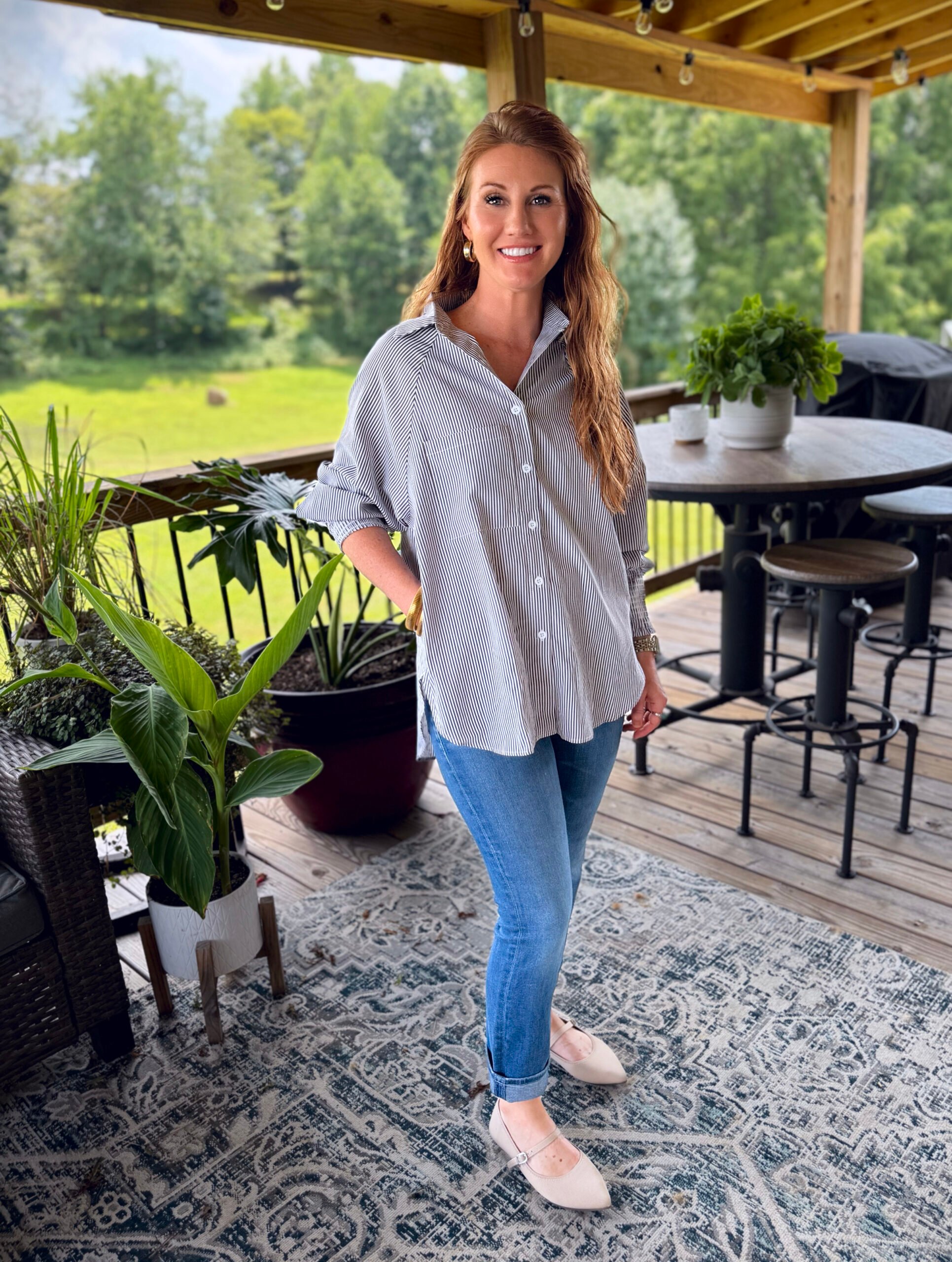 Stephanie, a petite 5'3" tall, wearing an oversized button up shirt from Amazon with jeans