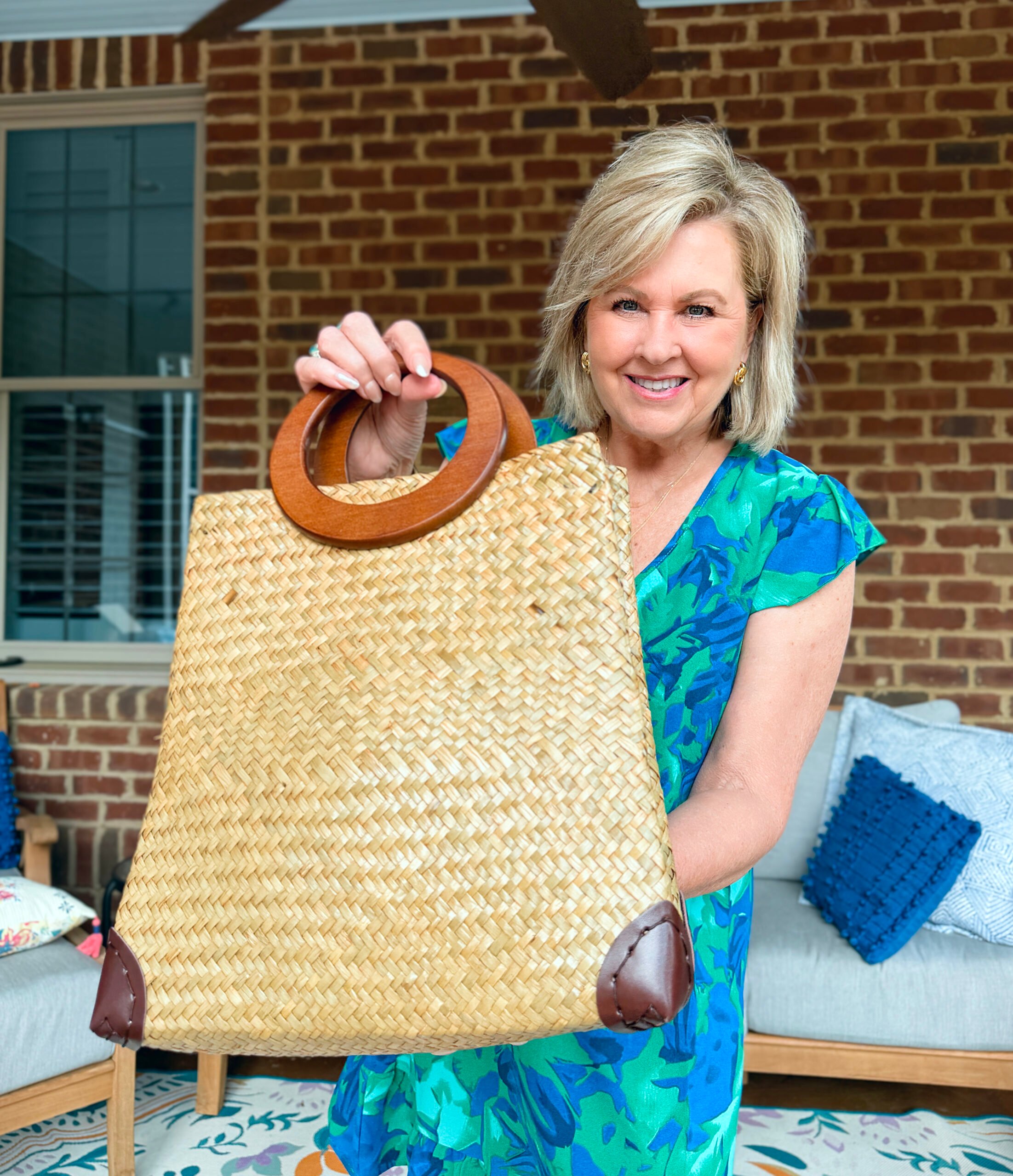 Tania holding a straw handbag with wooden handles