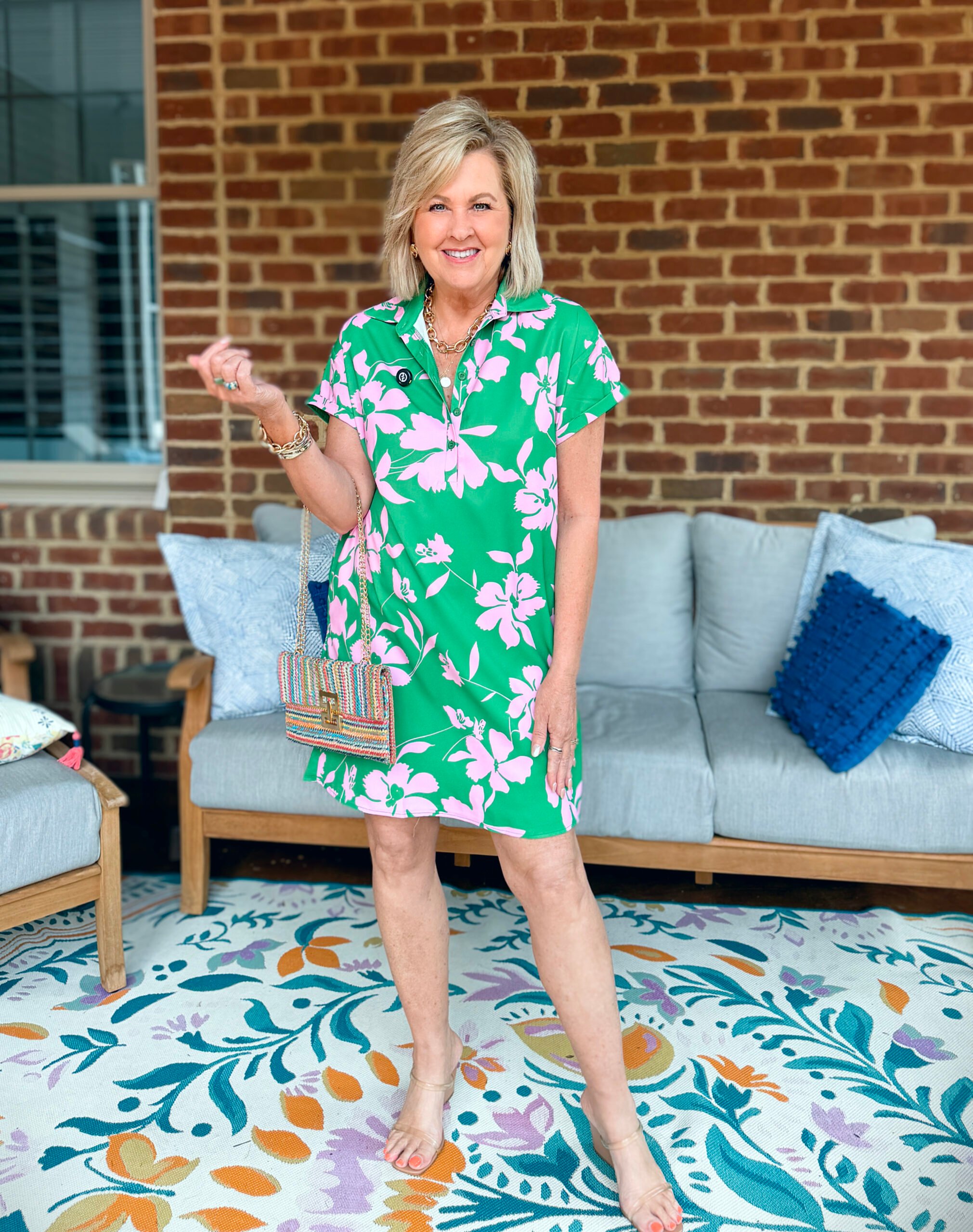Tania wearing a pink and green short dress from Amazon with a multi-colored clutch