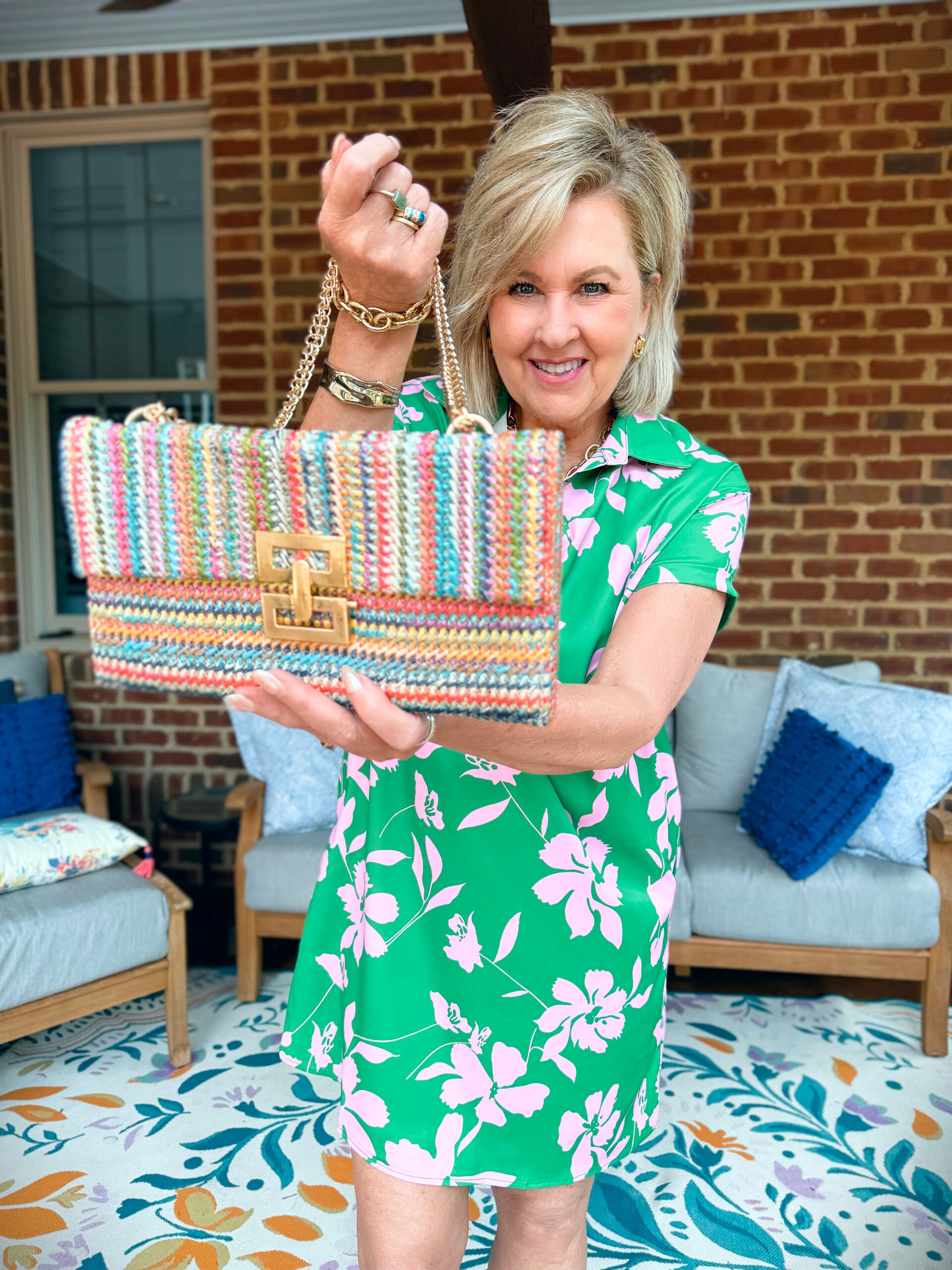 Tania holding a multi-colored clutch with a gold chain