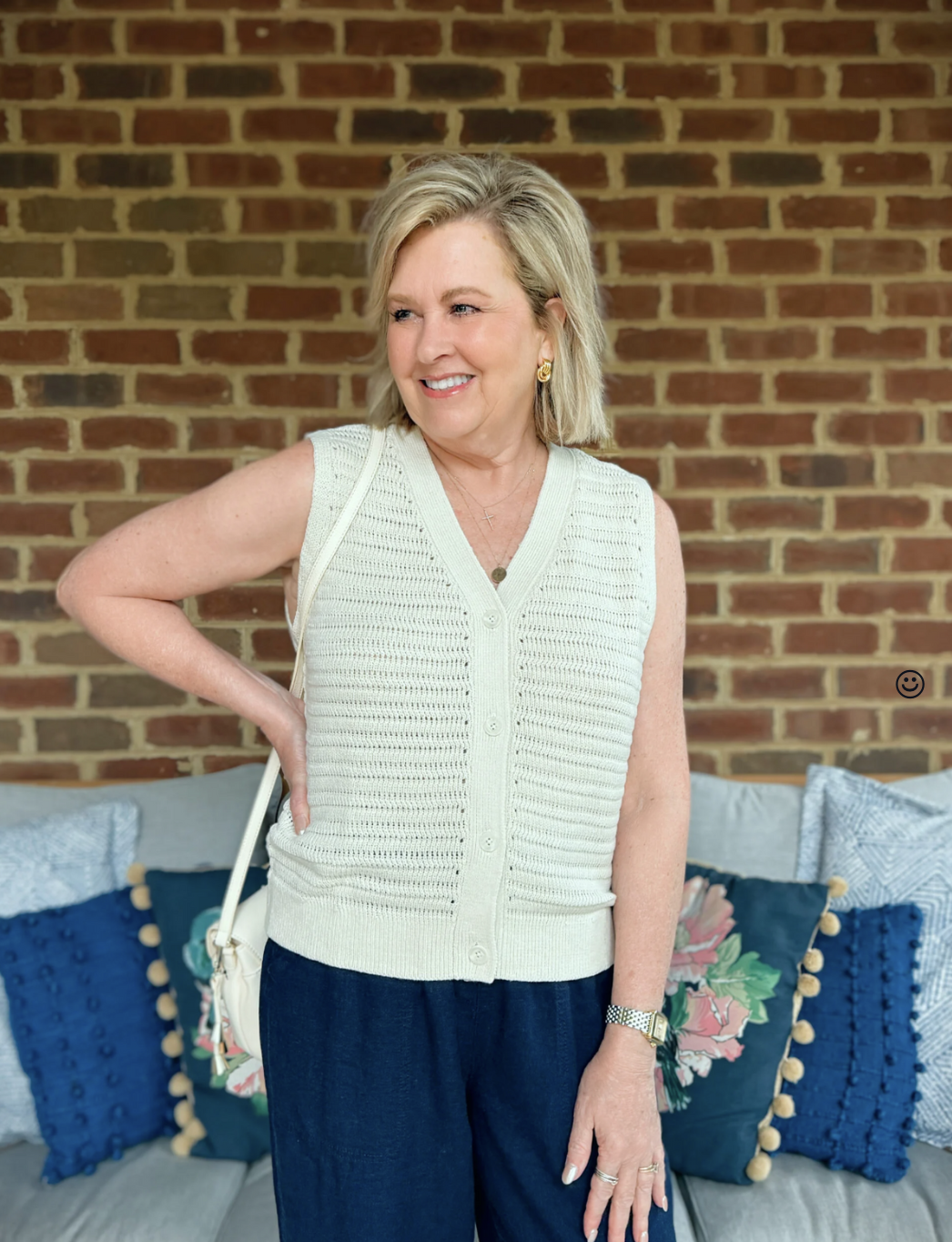 Open-knit button front sweater vest styled with wide-leg linen pants for summer-to-fall transition