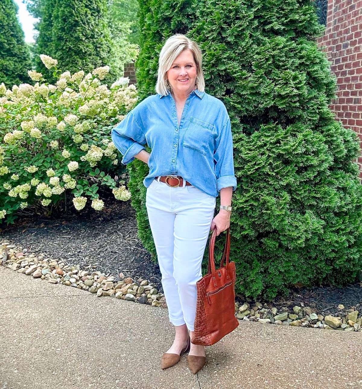 Tania in neutral ballet flats paired with white ankle jeans and a chambray shirt for a casual, polished spring outfit