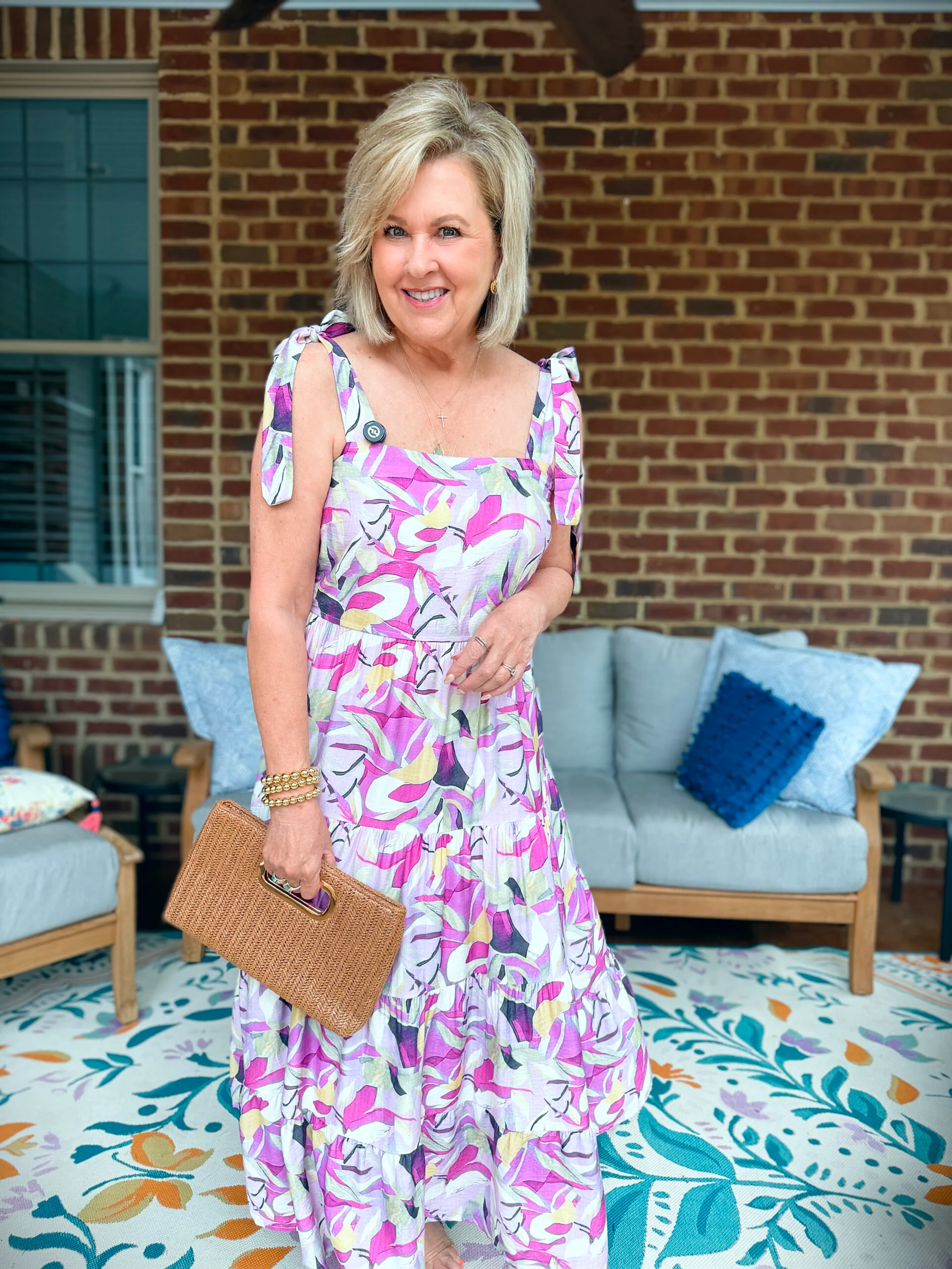 Woman wearing a Flowy Maxi Long Dress in  lilac and carrying a straw clutch