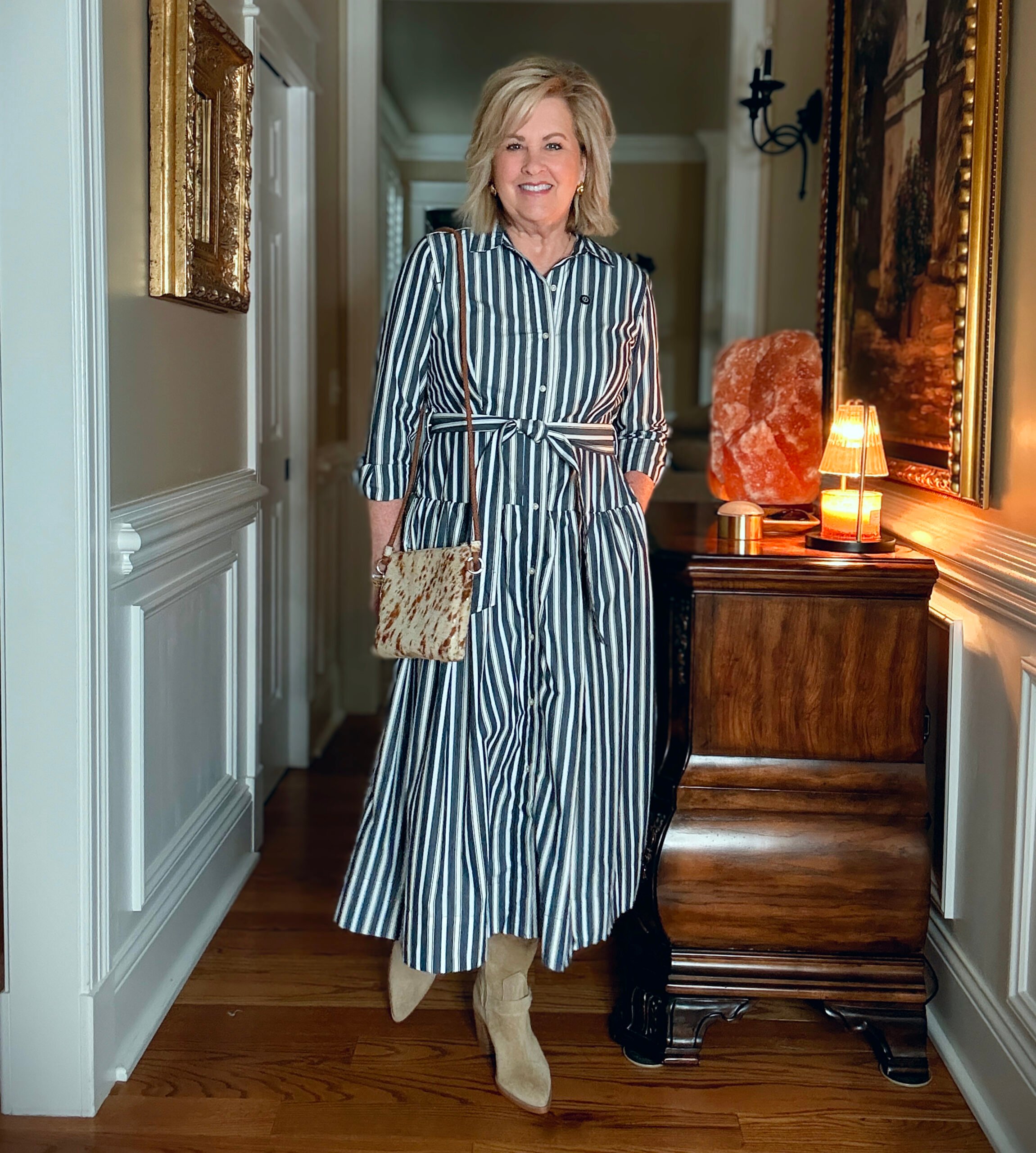 Tania is wearing a striped dress from Walmart and styling it with a western vibe.