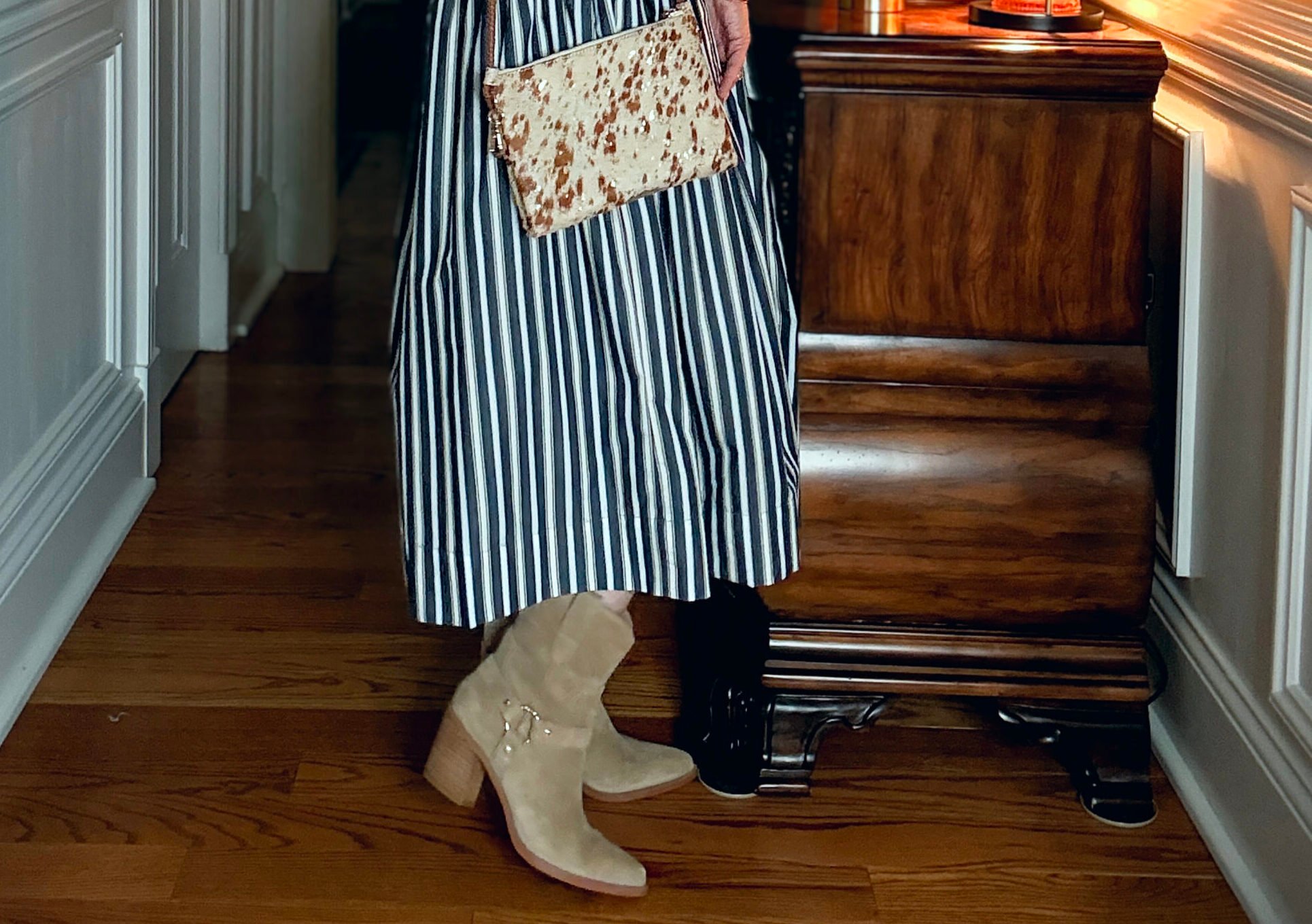 Tania is wearing a striped dress with western boots