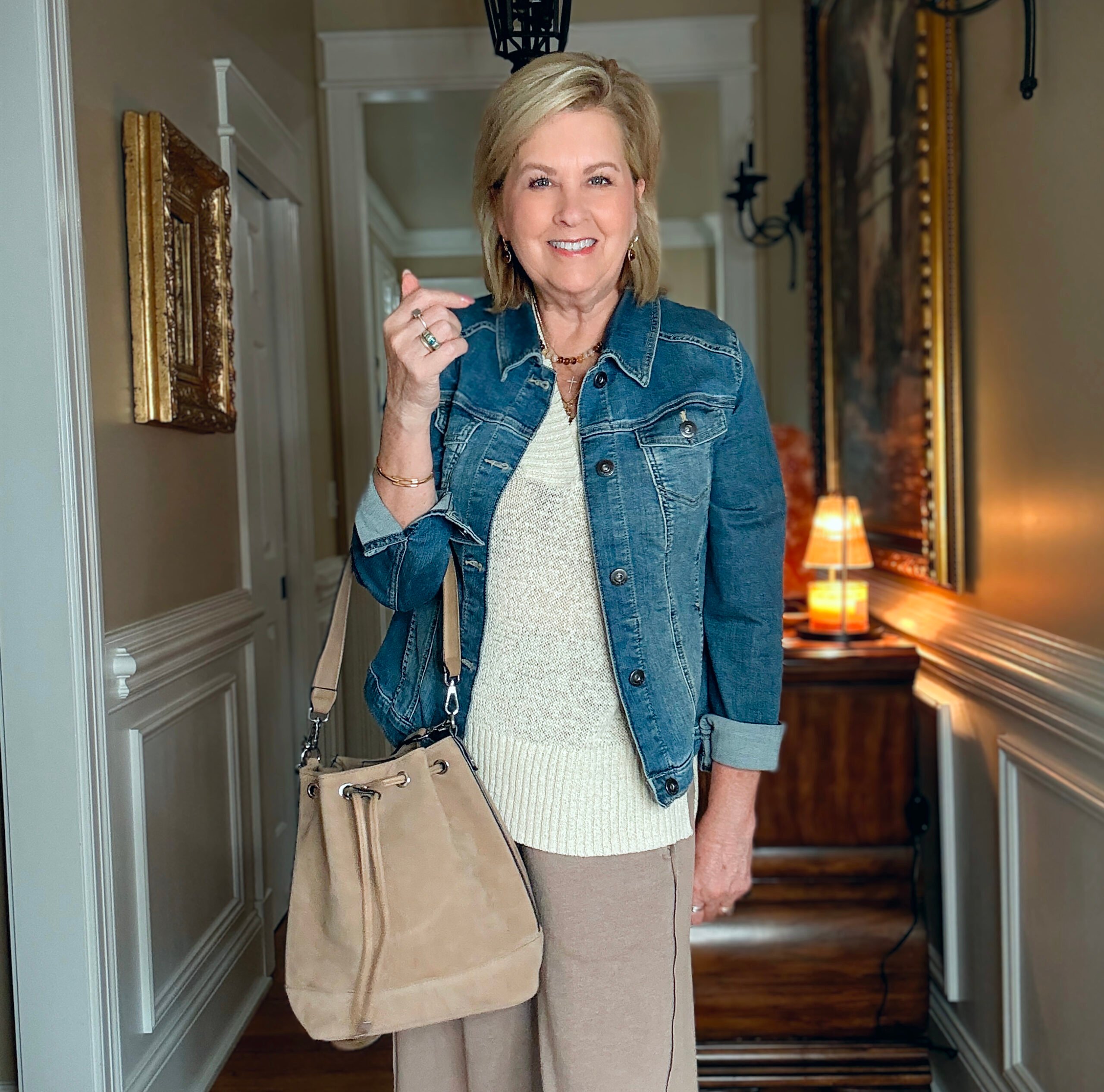 Tania is showing how to do a Summer to fall transition with jewelry, a denim jacket, boots, and a faux suede bucket bag