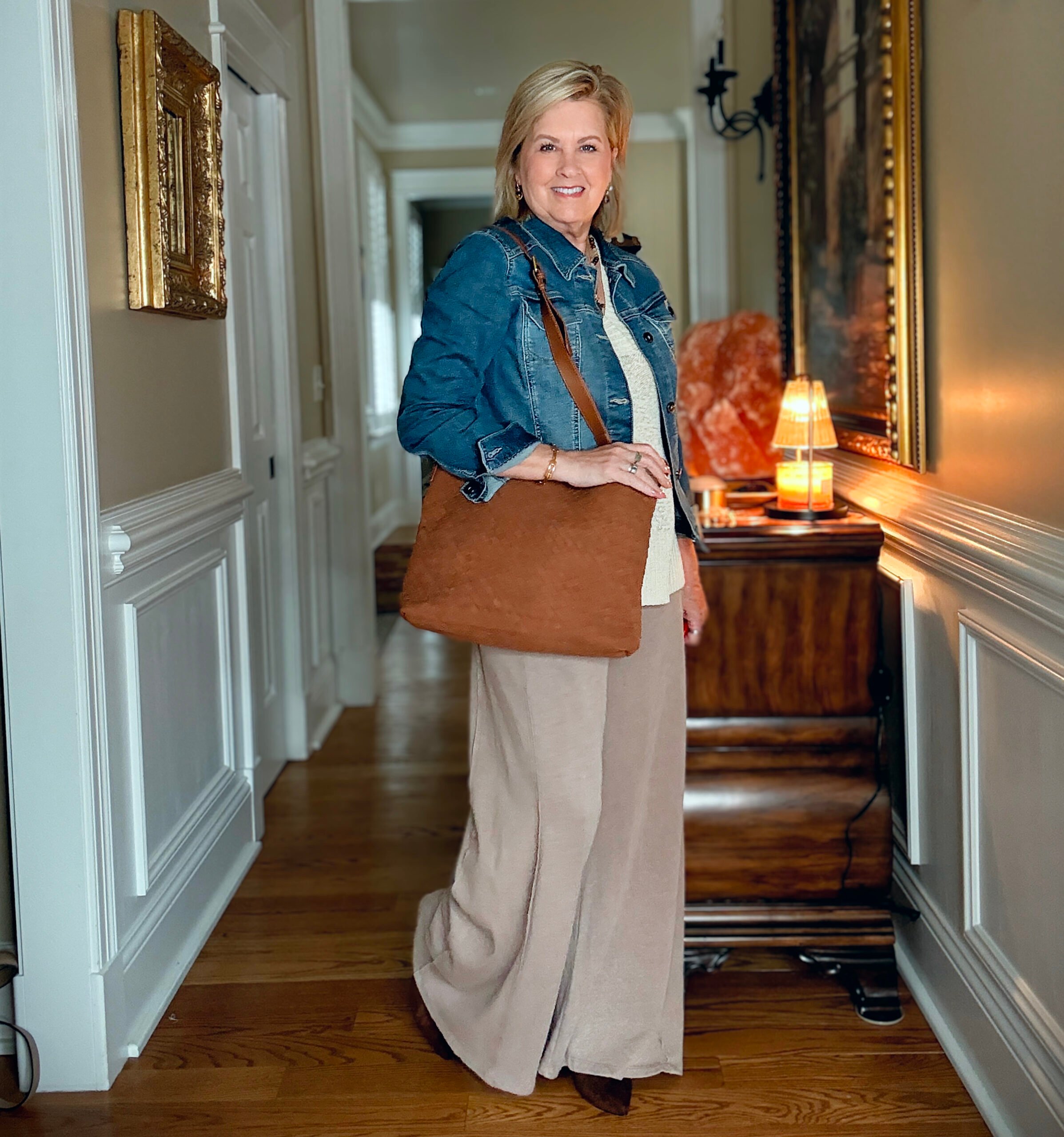 Tania is showing how to do a Summer to fall transition with jewelry, a denim jacket, boots, and a woven faux suede bag