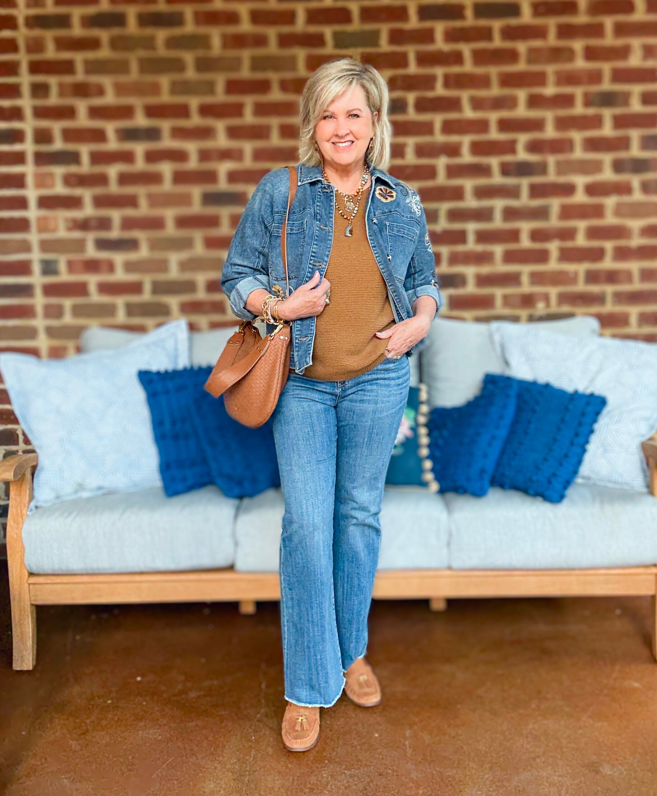 Tania Stephens wearing fall styles from Chico's - a denim jacket with brown sweater, shoes, and woven handbag