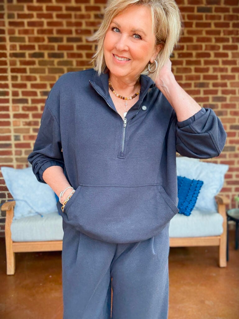 Tania wearing a navy cropped zip top and jewelry