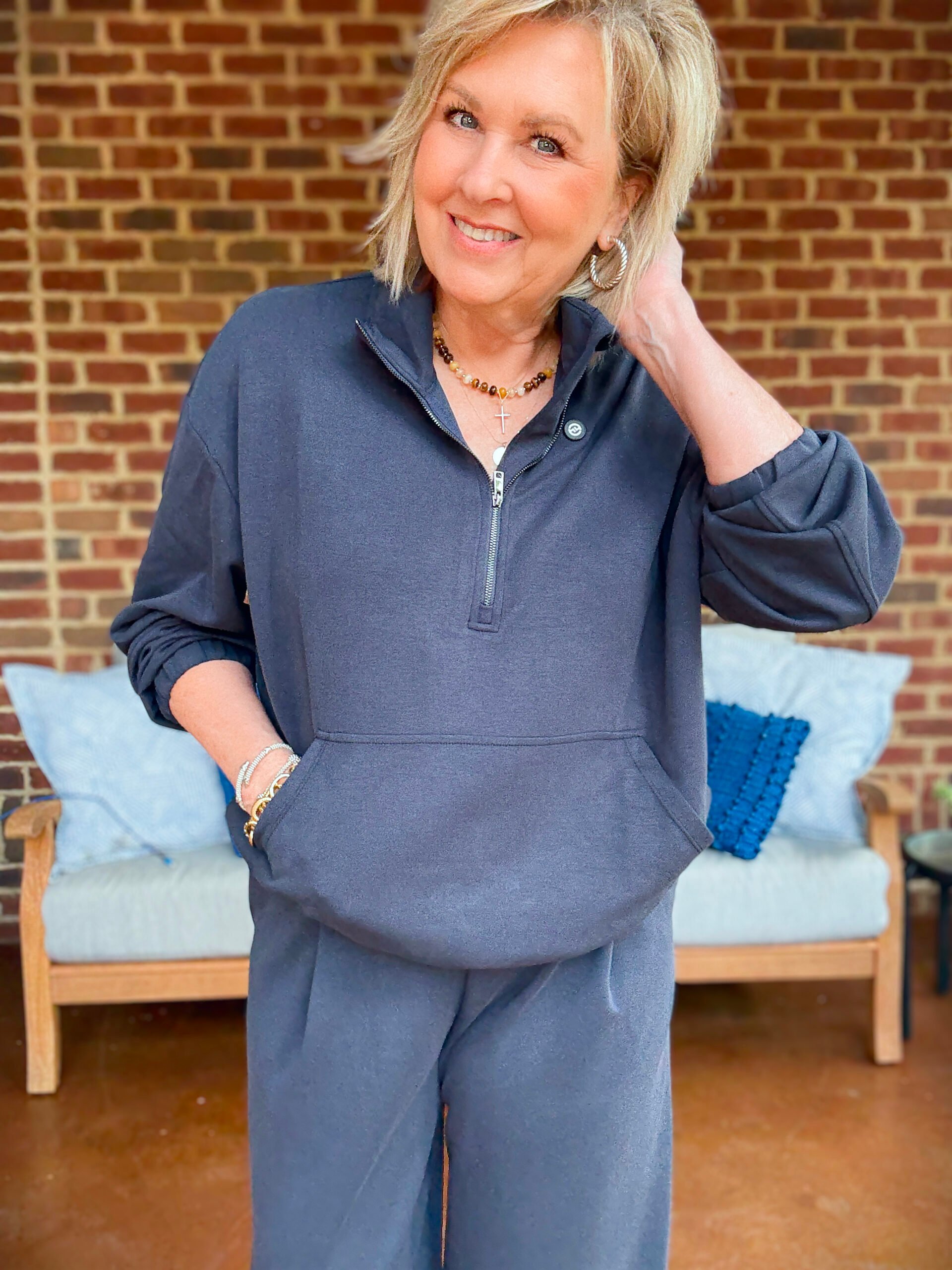 Tania wearing a navy cropped zip top and jewelry
