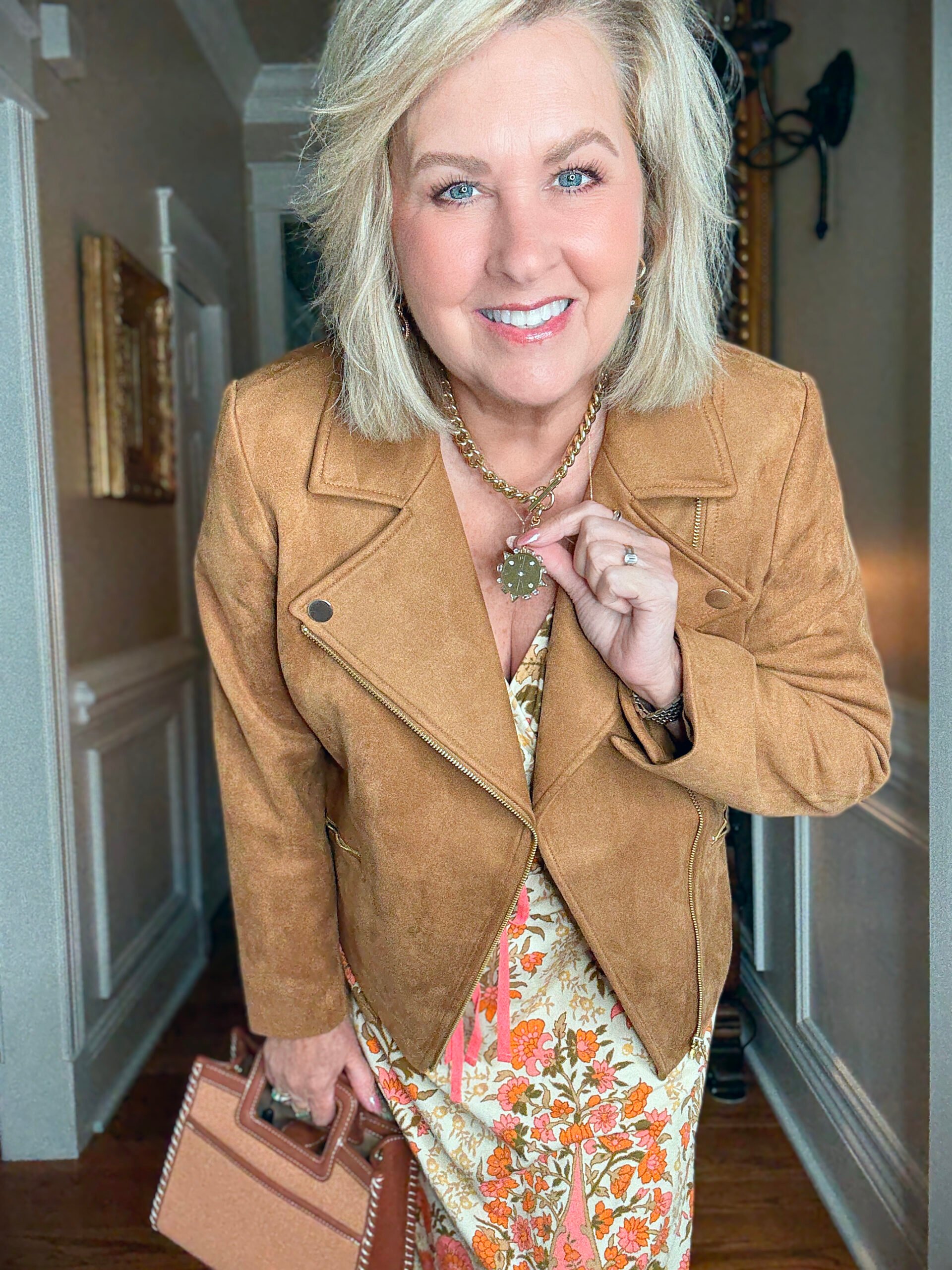 Tania Stephens showing a necklace with a faux suede jacket