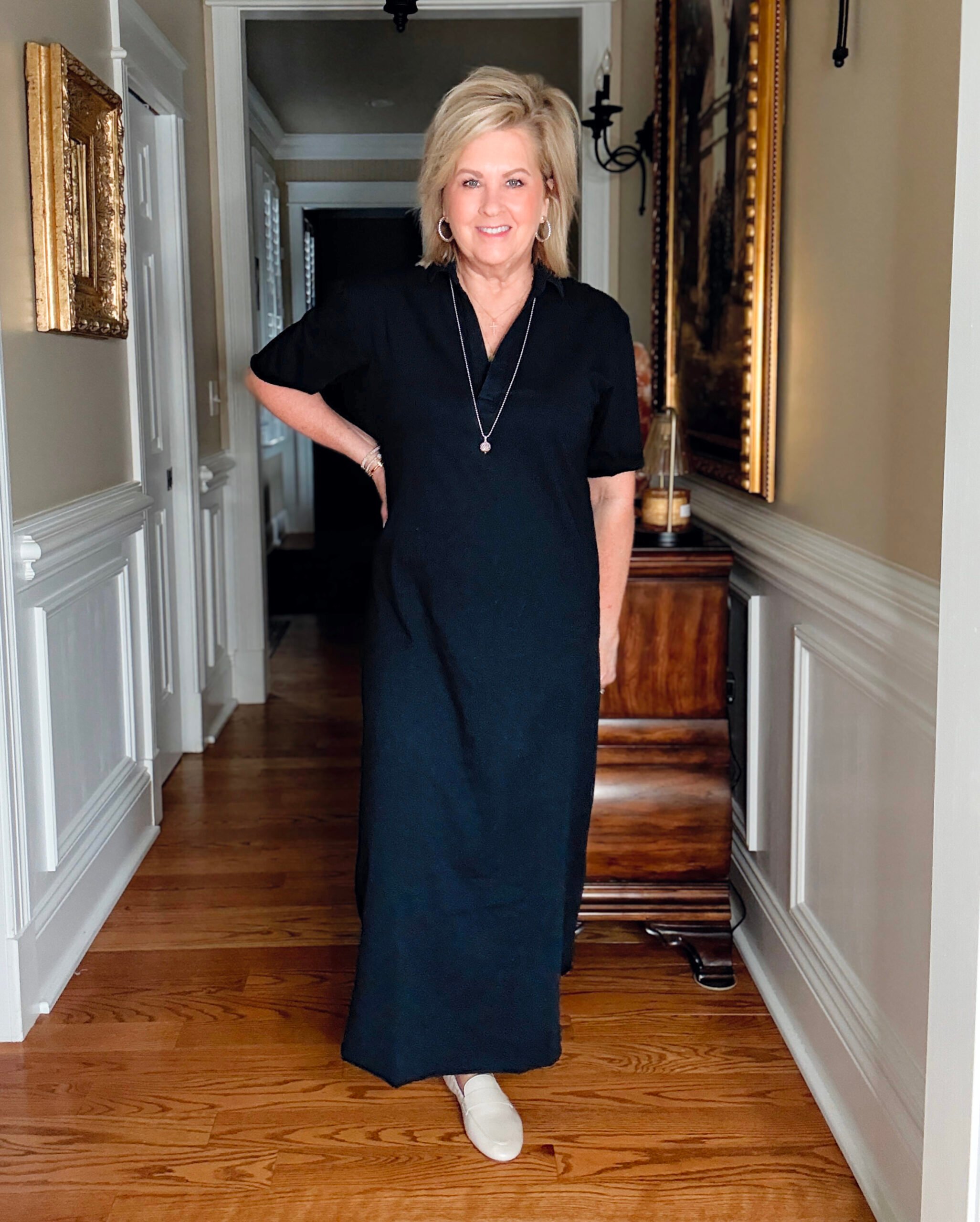 Navy maxi dress styled for women over 50 with neutral loafers, silver pendant necklace, and animal print scarf for a chic travel outfit