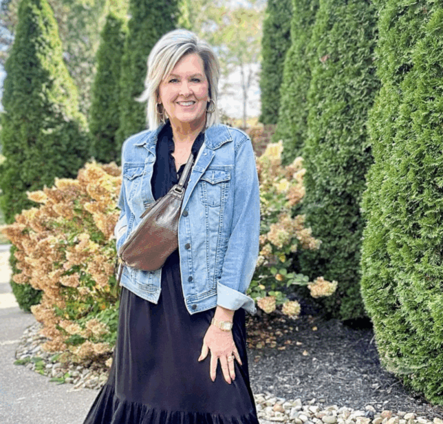 Fashion Blogger over 50, Tania is styling a black dress with a denim jacket
