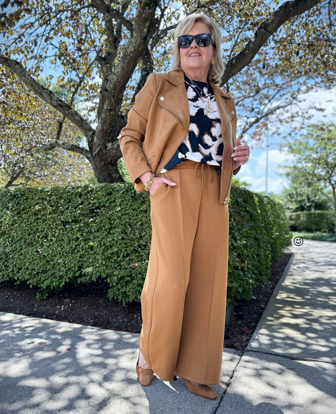 Tania wearing an air-knit short sleeve floral top with pleated pants from Talbots for an early fall transition outfit